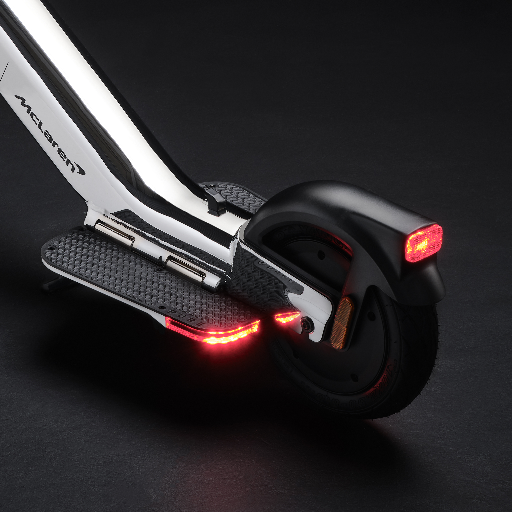Ein silberner E-Scooter mit McLaren-Logo und roten Lichtern.