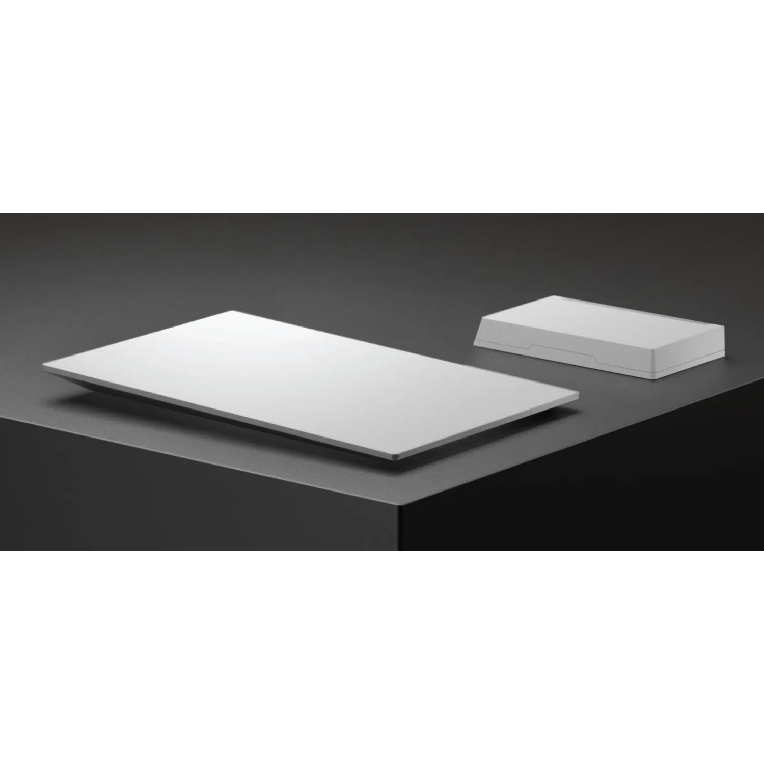 A white rectangle and a white box on a dark pedestal.