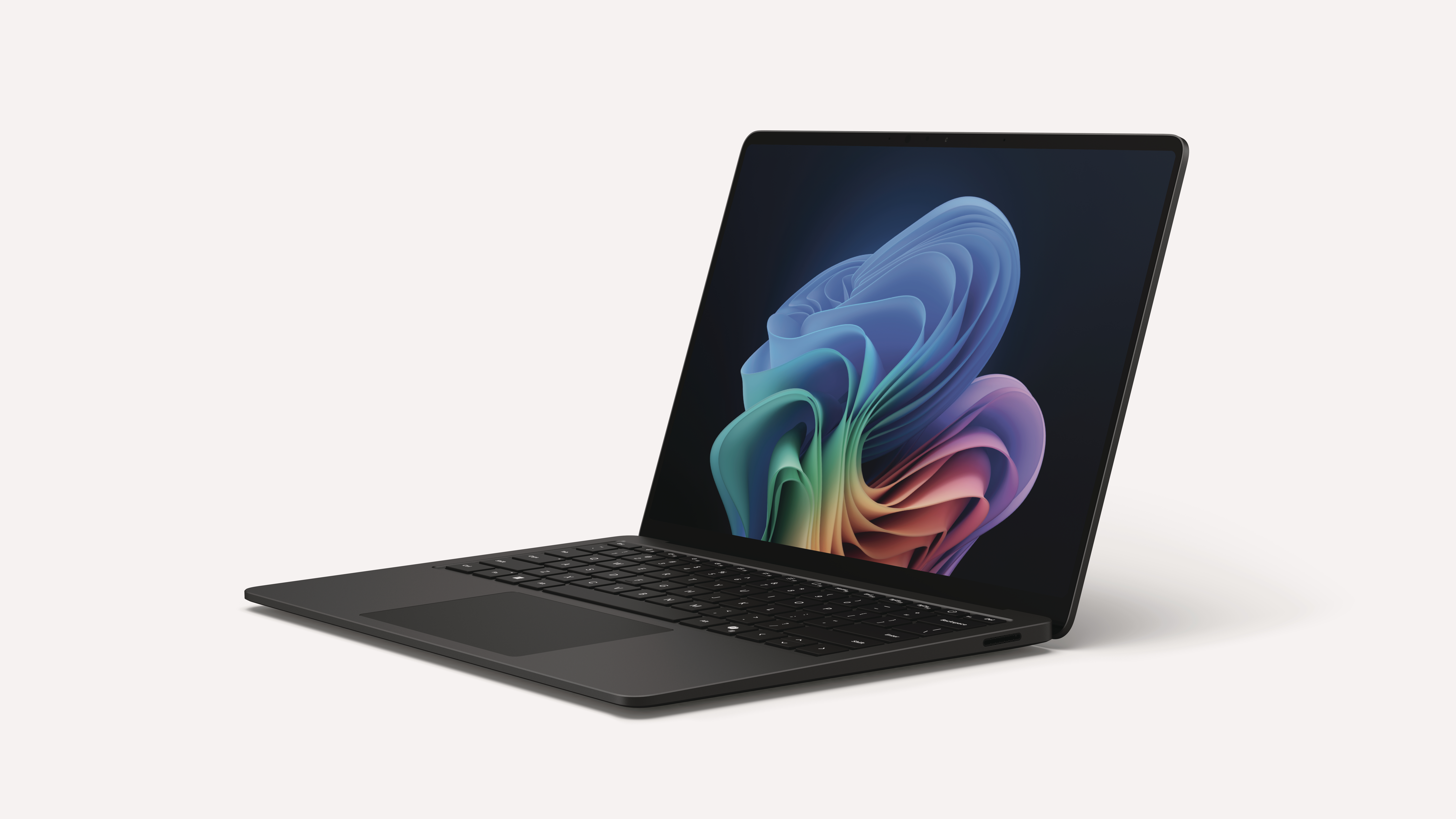 Ein dunkles, geöffnetes Laptop mit einem bunten, abstrakten Hintergrundbild auf dem Bildschirm.