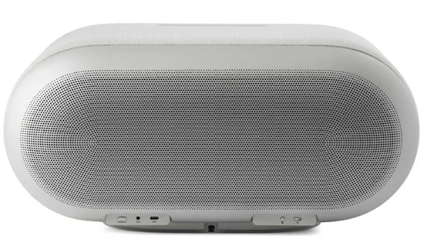 Owalny, biały głośnik Bluetooth z perforowaną kratką i przyciskami.