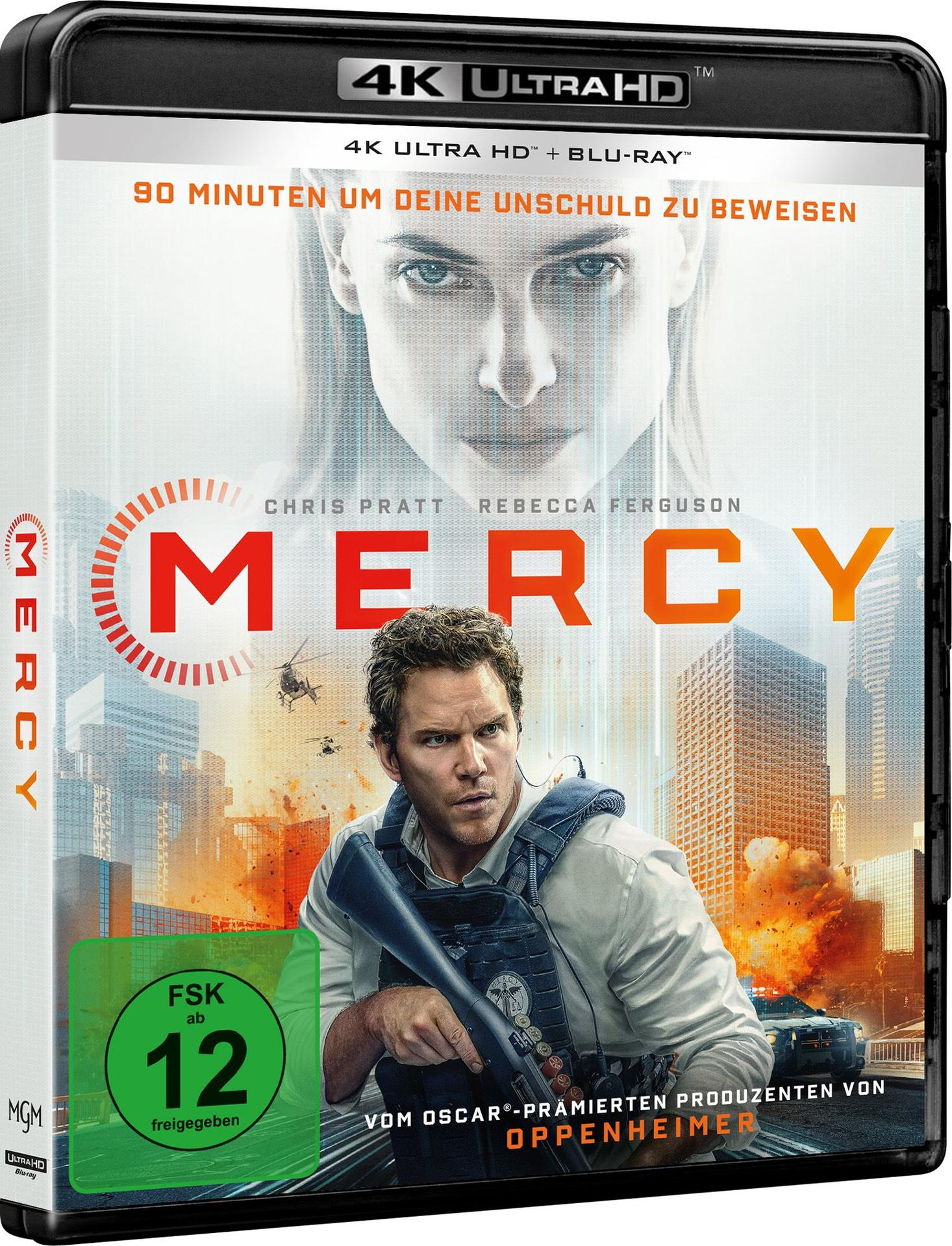 Ein Mann mit Weste und Waffe vor explodierender Stadtkulisse. Titel: Mercy.