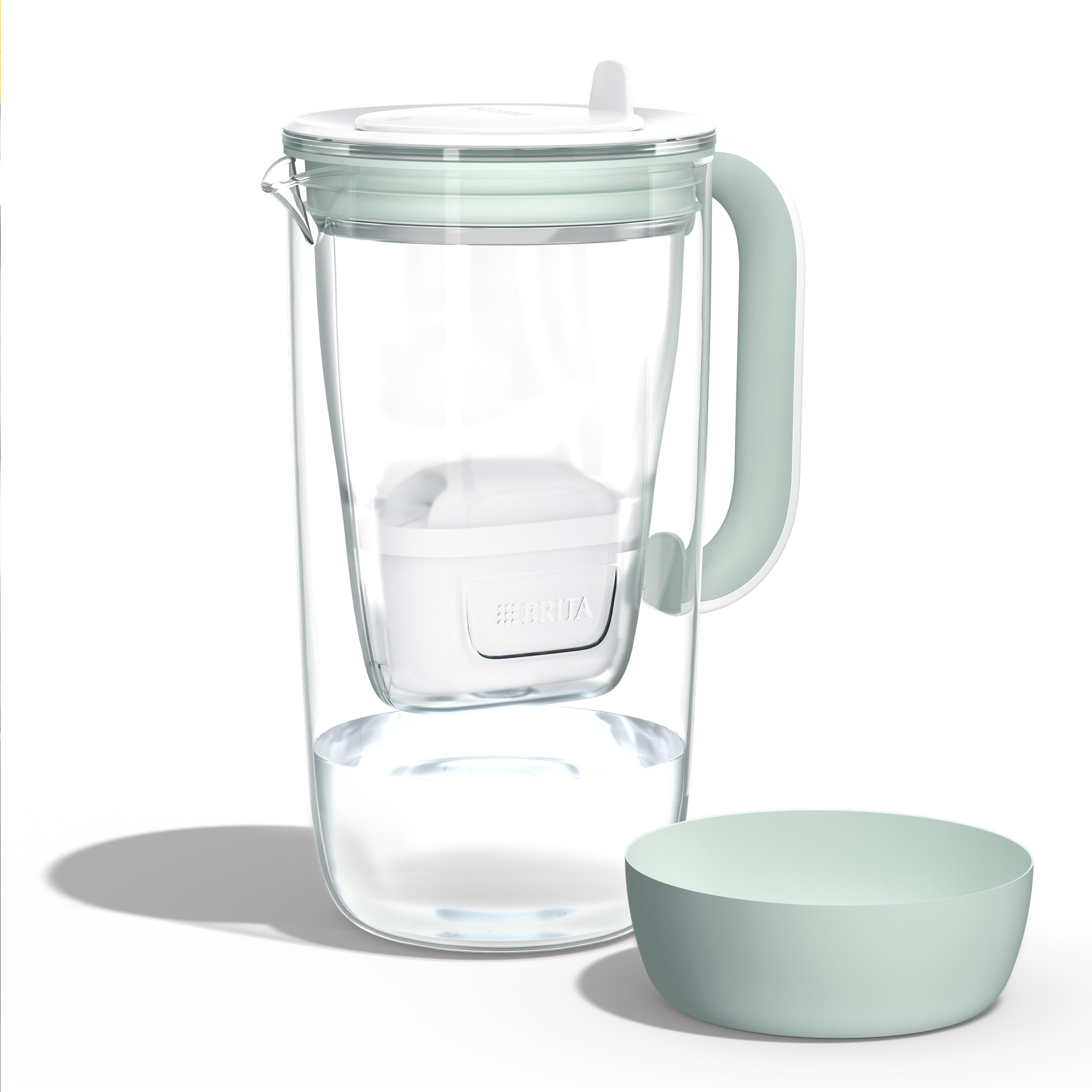 Ein transparenter Wasserfilterkrug mit einem grünen Griff und Deckel, daneben eine grüne Schale.