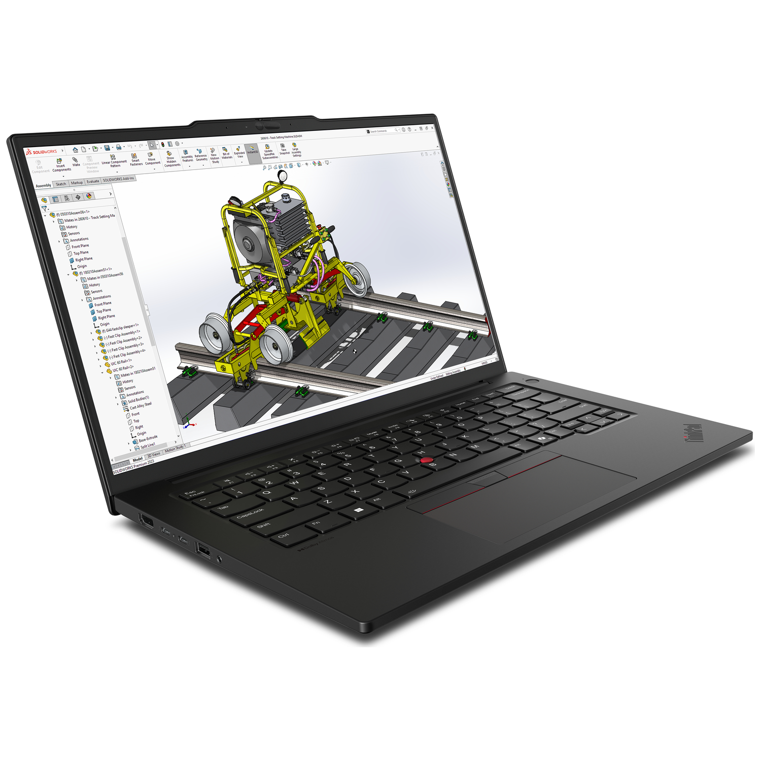 A black laptop displays a 3D design of a yellow machine on rails.