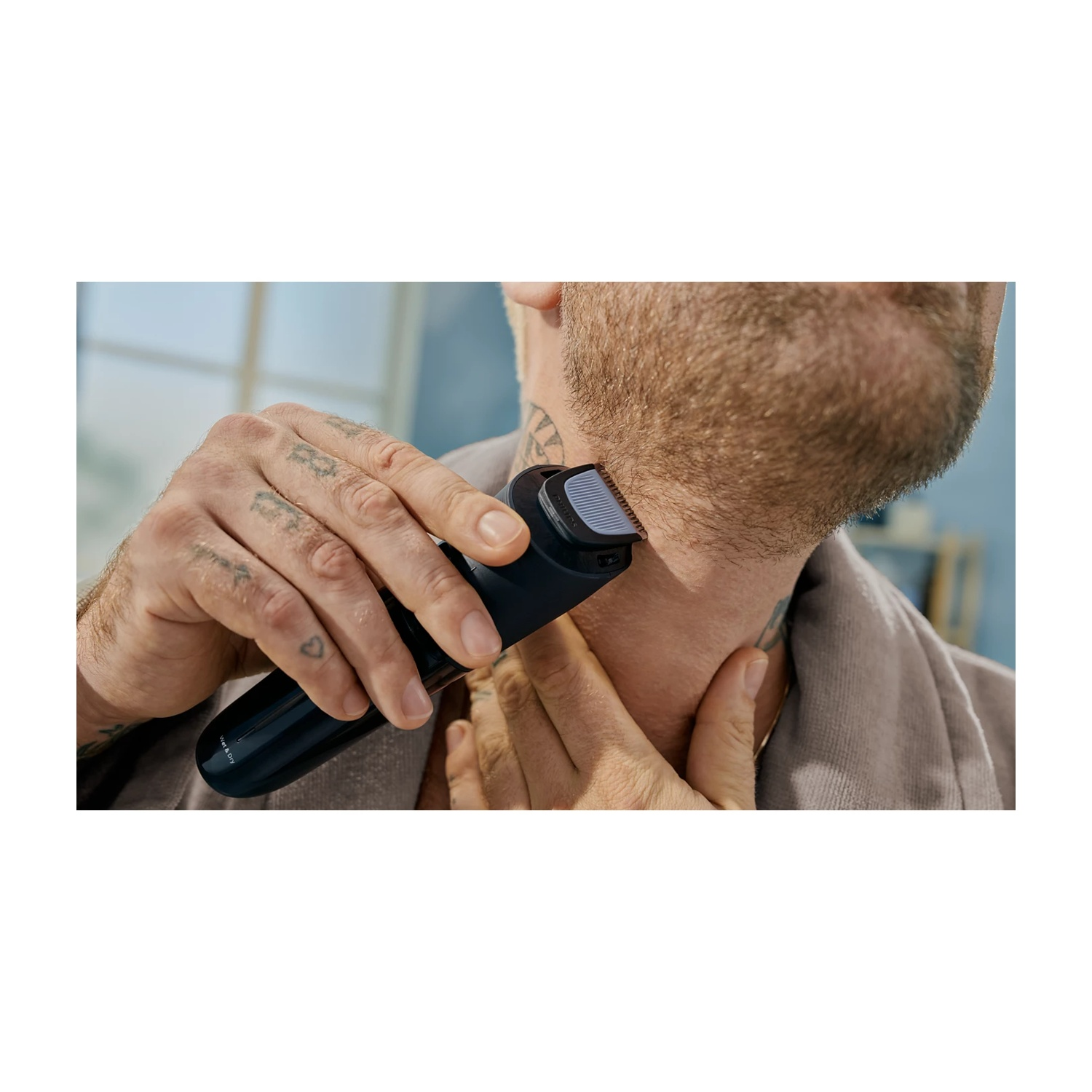 Uomo che si taglia la barba con un rifinitore nero sul collo.