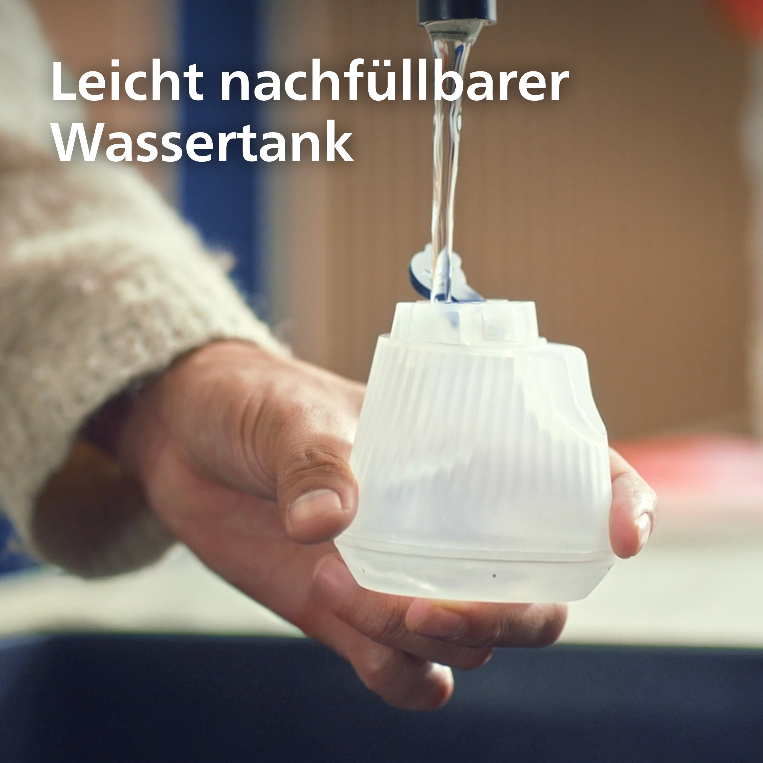 Eine Hand füllt einen durchsichtigen Wassertank unter einem Wasserhahn.