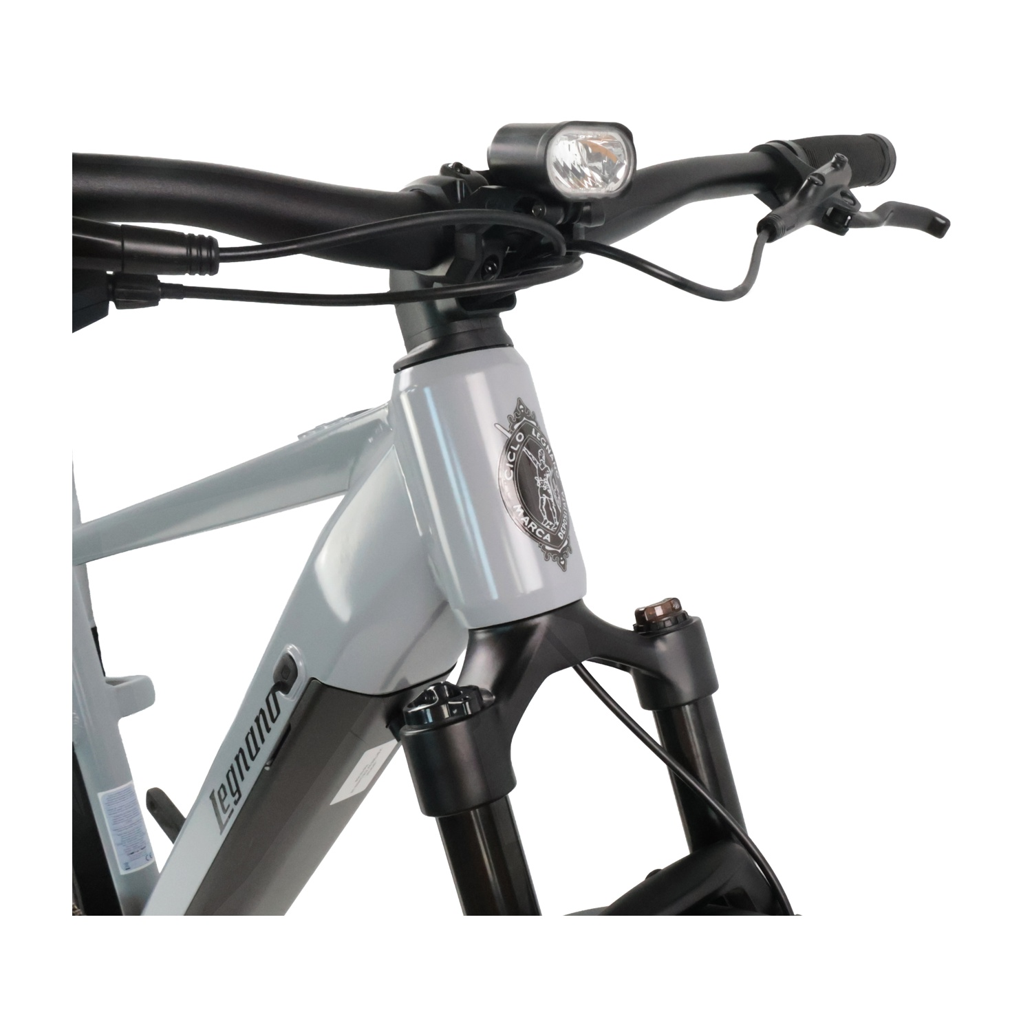 Bicicletta grigia con manubrio nero, luce e forcella ammortizzata.