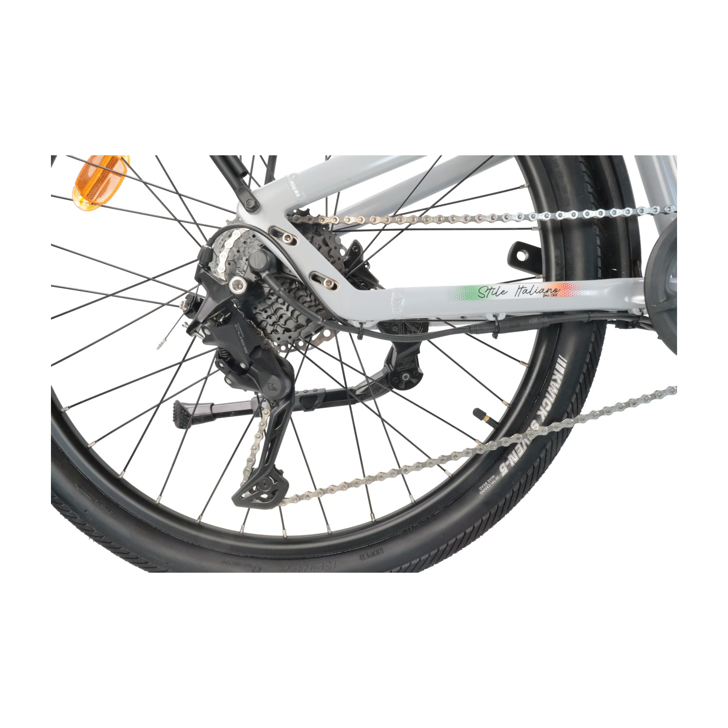 Primo piano della ruota posteriore di una bicicletta, che mostra deragliatore, ingranaggi, catena e pneumatico.