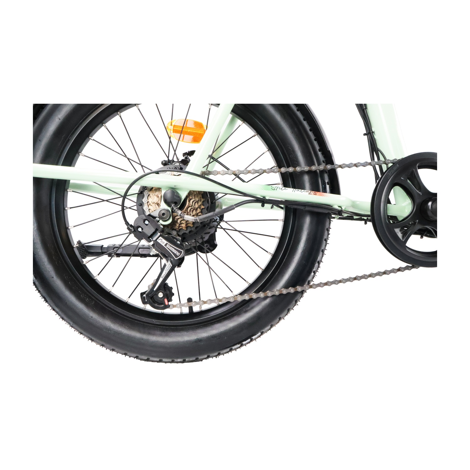 Primo piano della ruota posteriore di una bici verde menta, con catena e cambio.