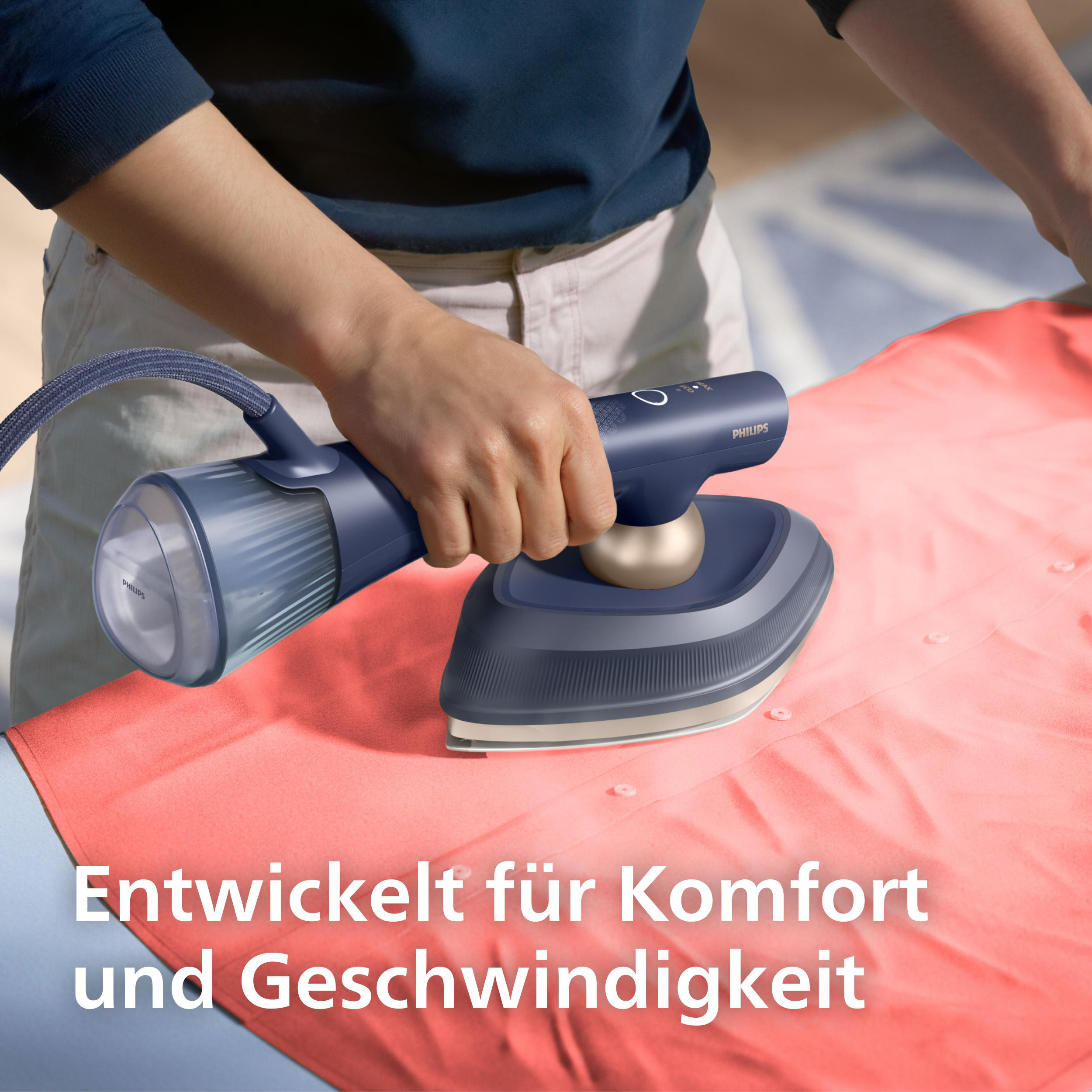 Eine Person bügelt ein helloranges Hemd mit einem blauen Dampfbügeleisen.