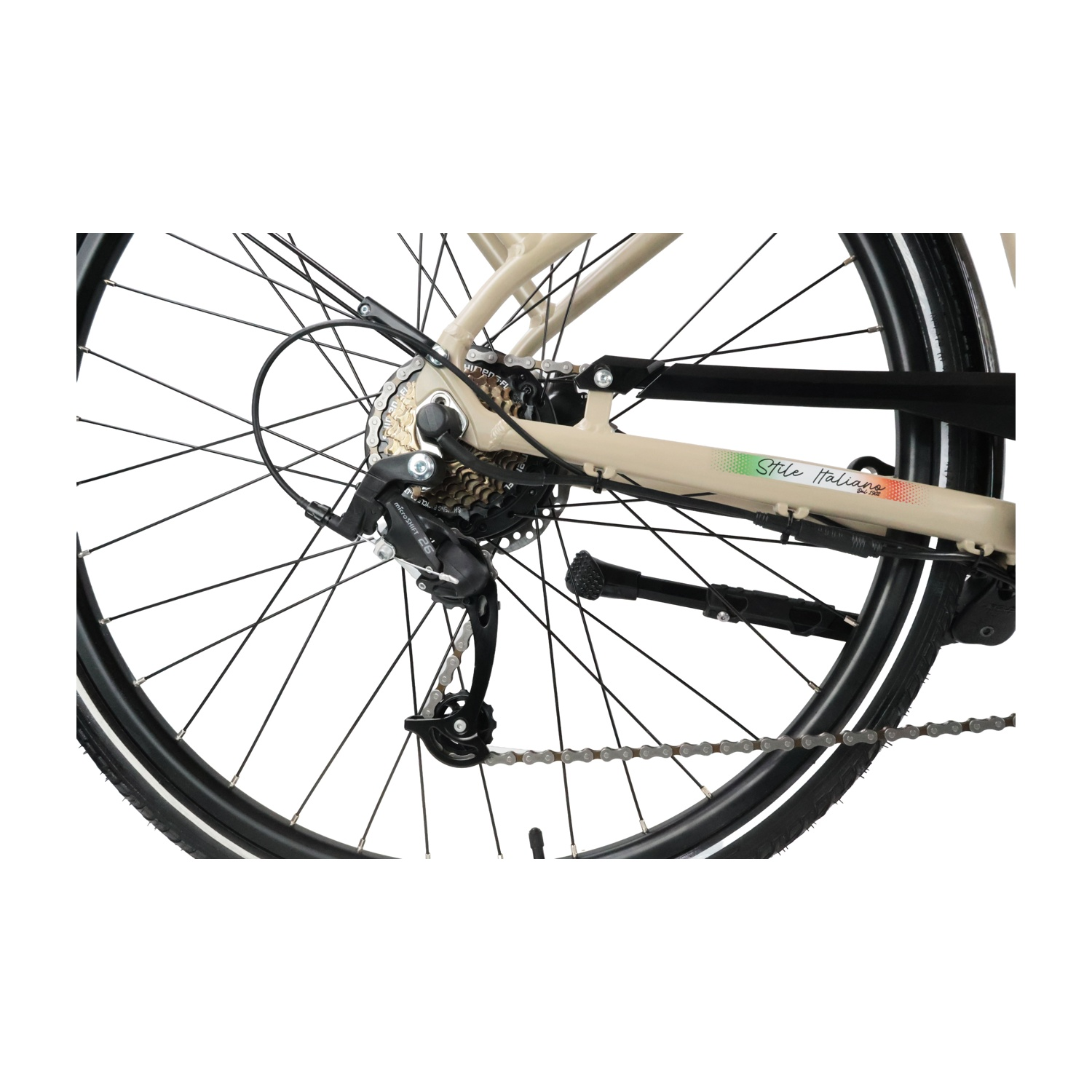Primo piano della ruota posteriore di una bicicletta beige, con catena e deragliatore.