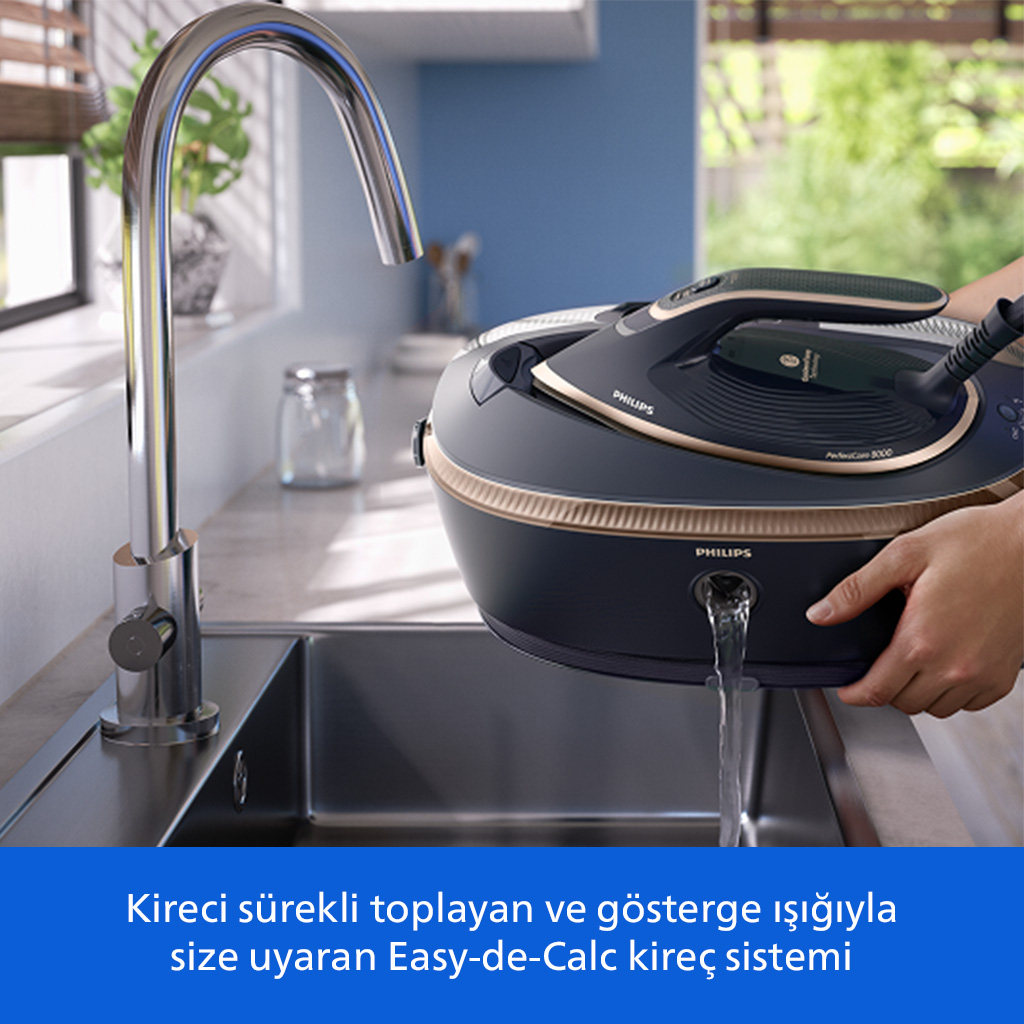 Buharlı ütü lavabonun üzerinde boşaltılıyor. Cihazdan su akıyor.