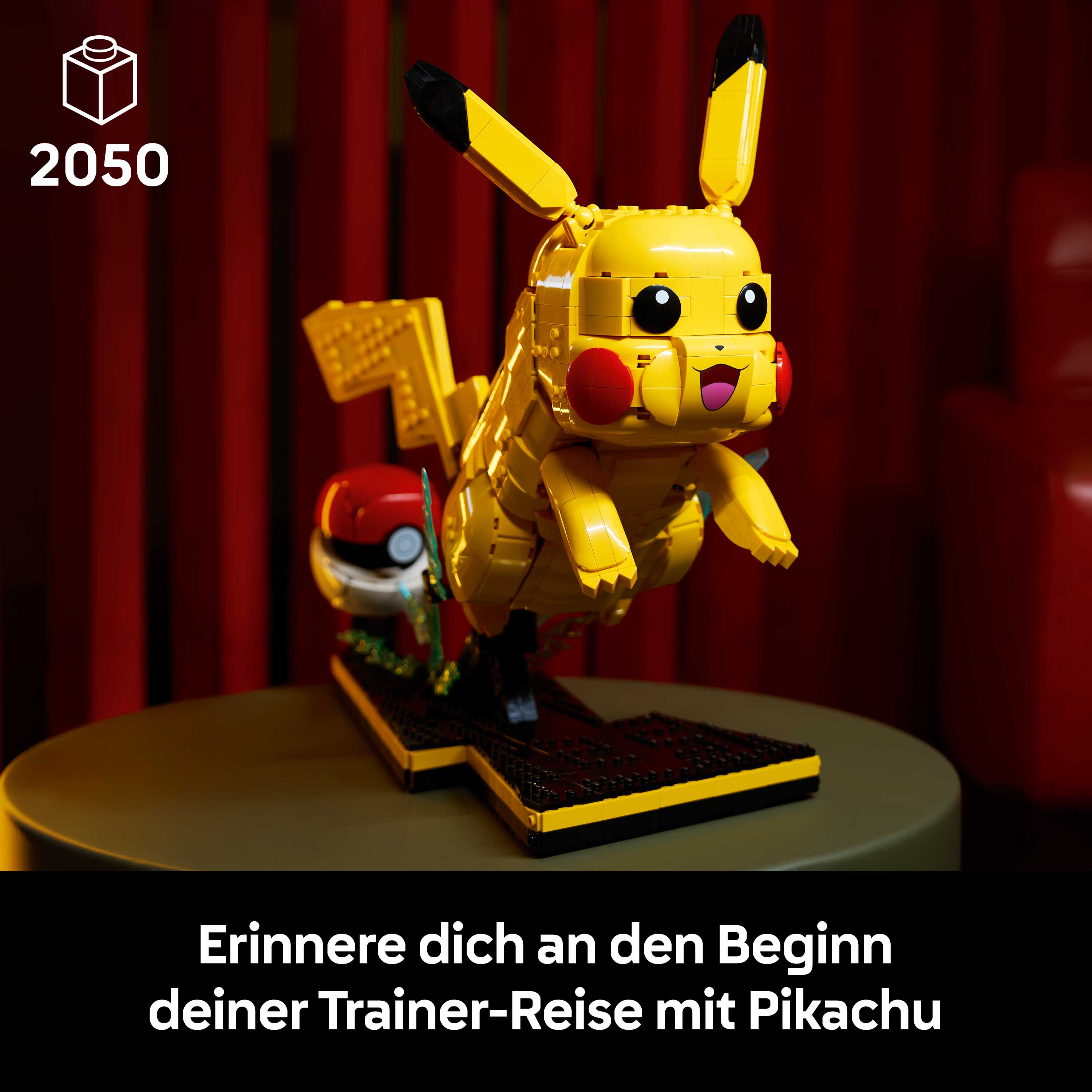 LEGO Pikachu mit Pokéball auf einer schwarzen und gelben Basis vor rotem Hintergrund.