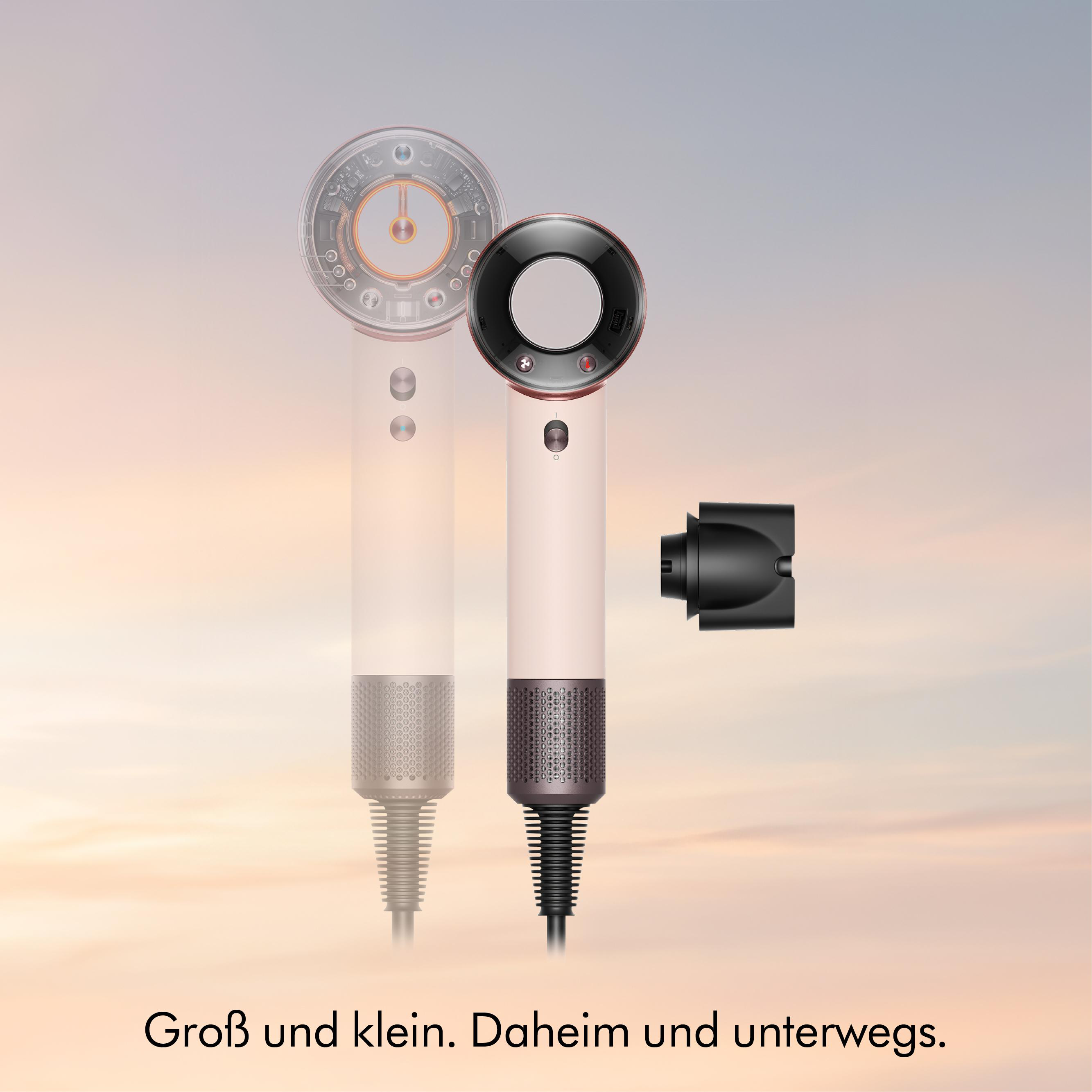 Zwei Haartrockner, einer transparent, mit schwarzem Aufsatz vor einem Himmel.