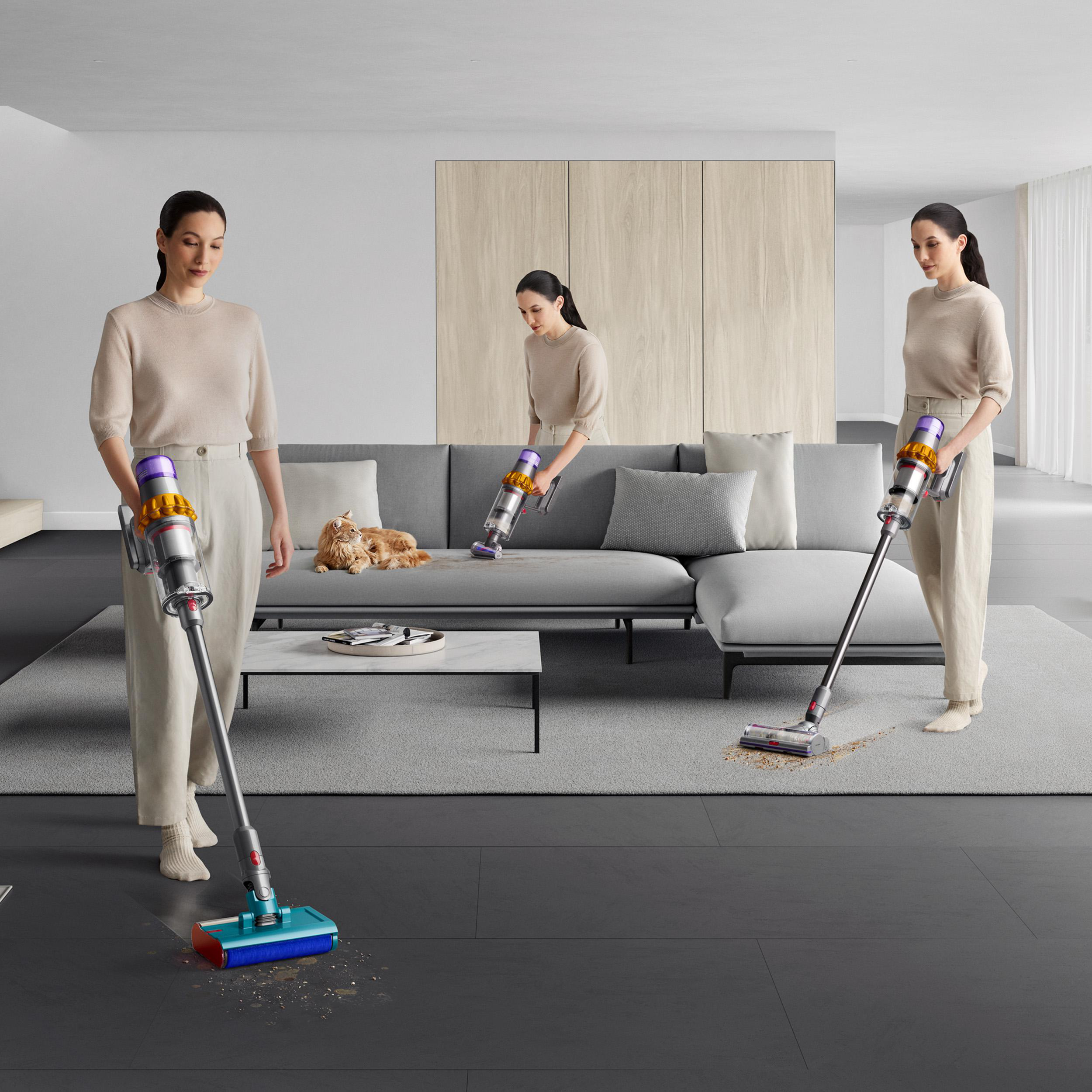 Eine Frau saugt ein Wohnzimmer mit einem Dyson Staubsauger.