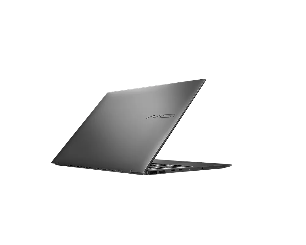 Ein geschlossener, silberner MSI-Laptop mit beleuchtetem Logo auf schwarzem Hintergrund.