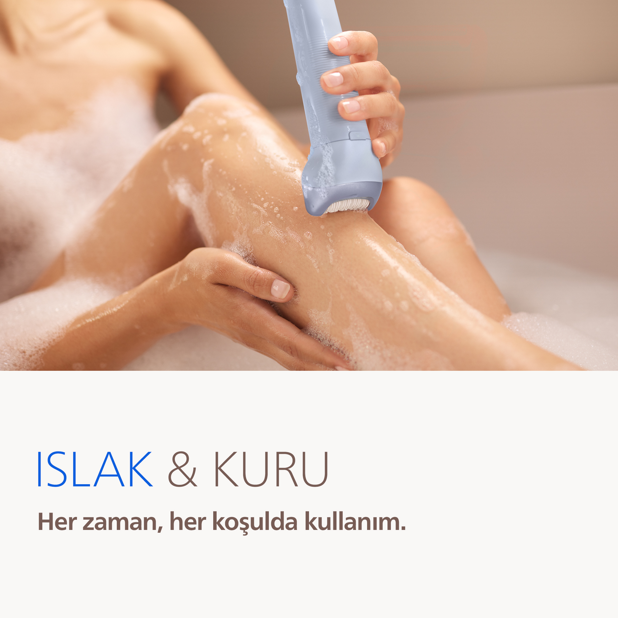 Bir el, köpüklü küvette bir kadının bacağında epilatör kullanıyor.