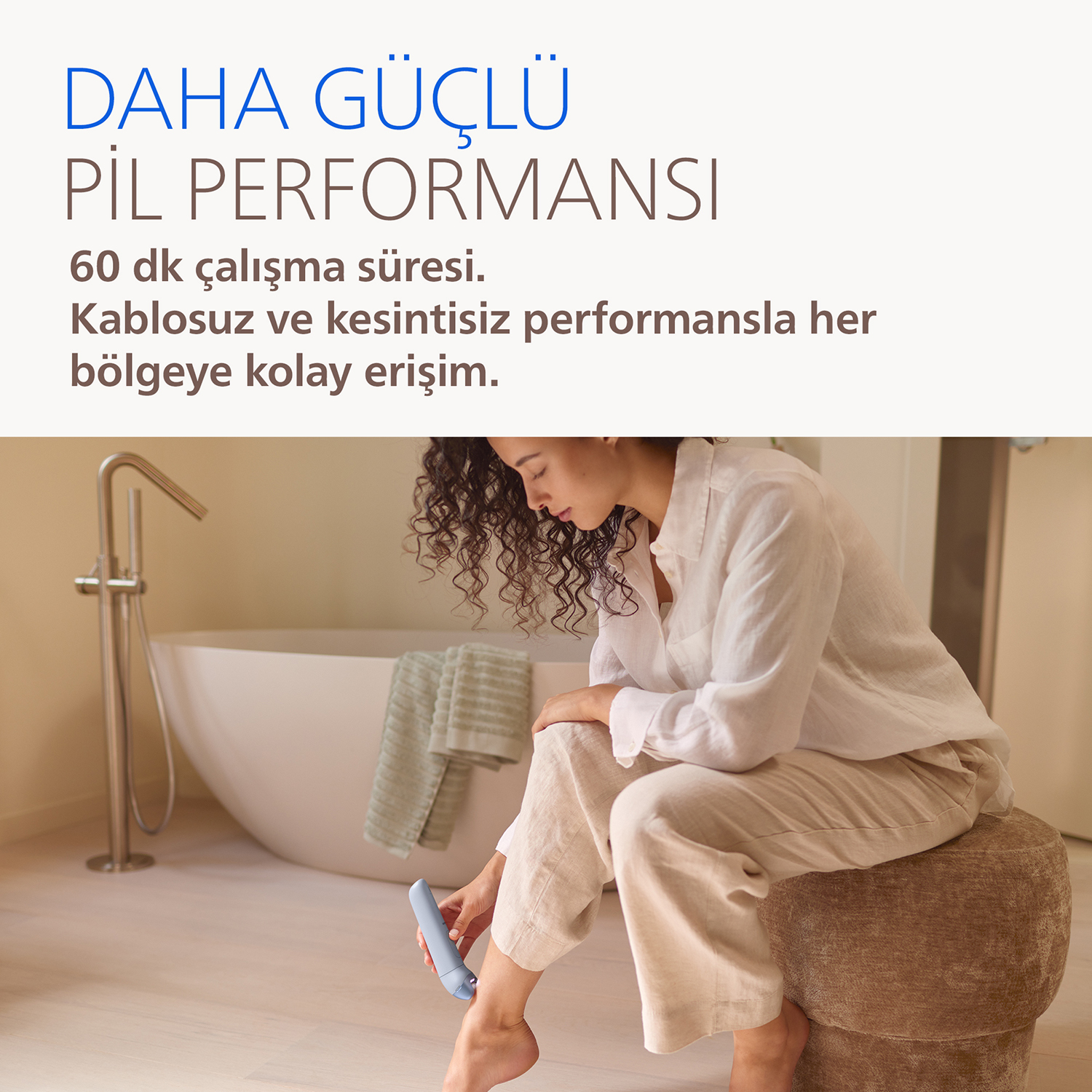 Kadın banyoda bacağına epilatör kullanıyor.