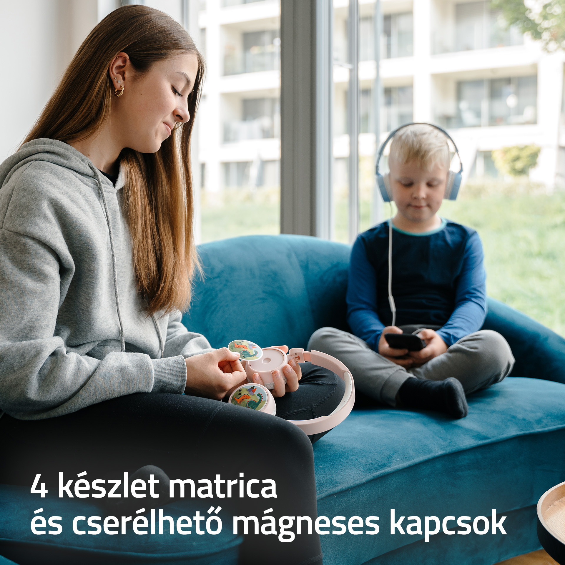Lány fejhallgatóval rózsaszín, dinoszauruszos matricás fejhallgatót tart.