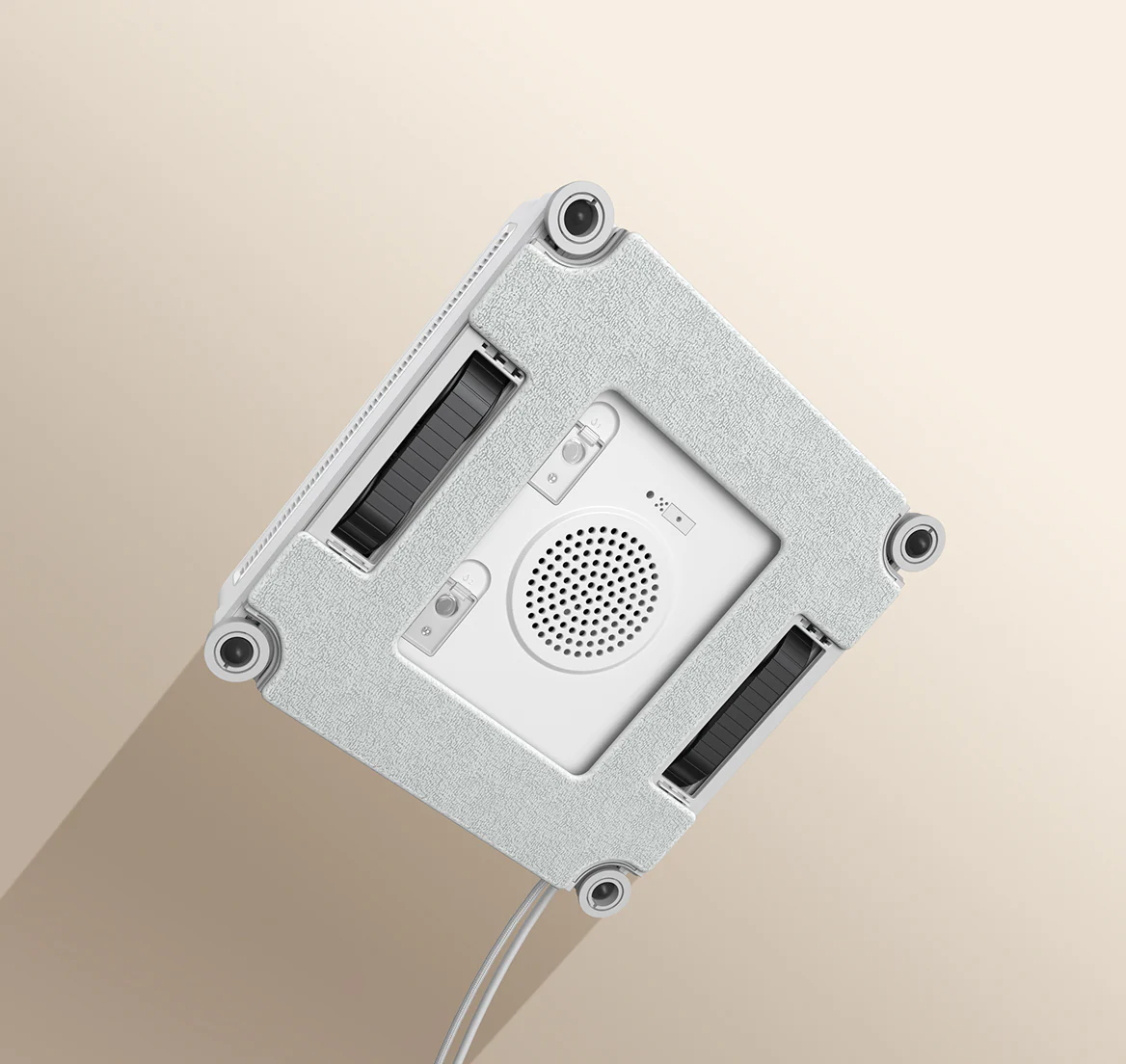 Un robot lavavetri bianco con angoli in gomma grigia su sfondo beige.