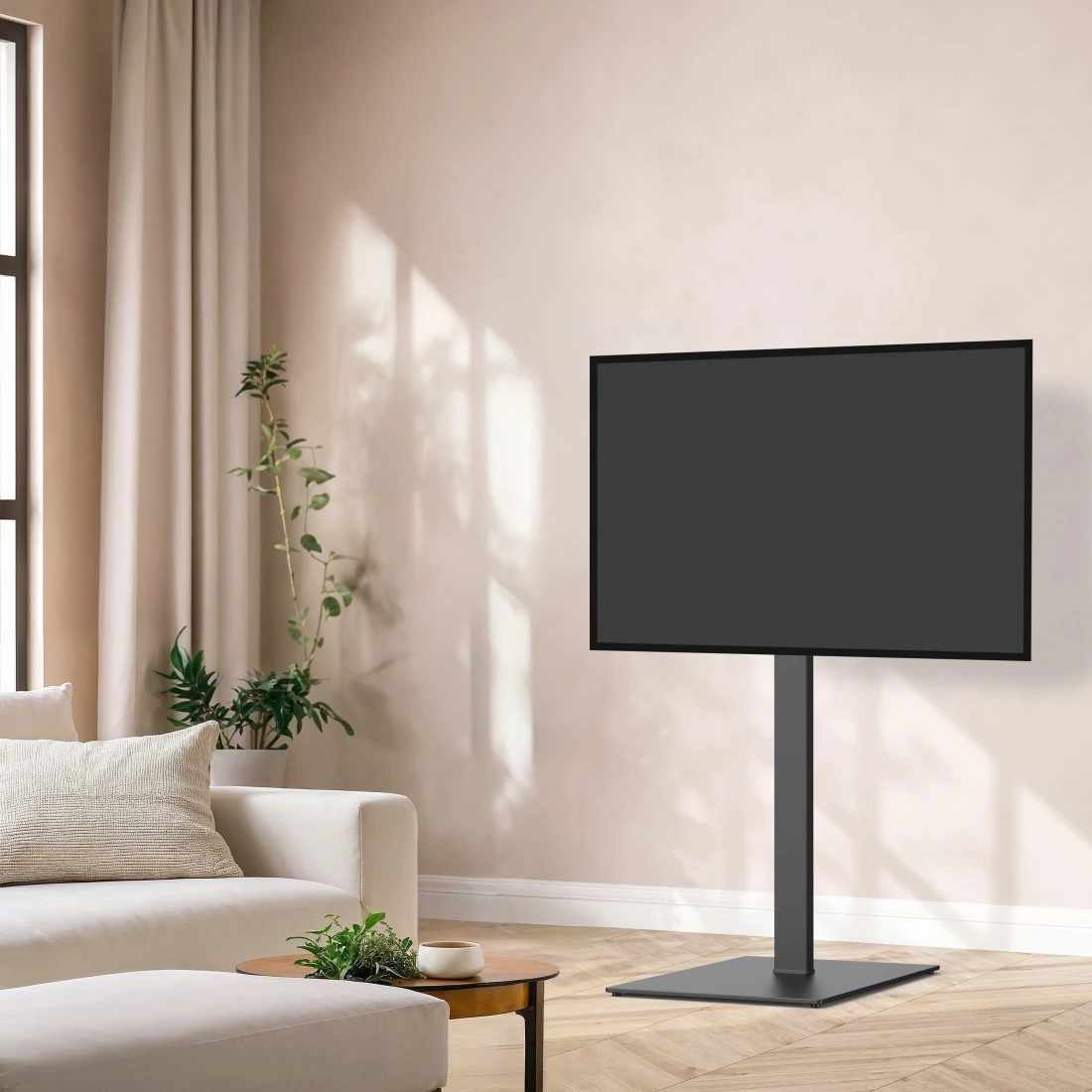 Téléviseur moderne à écran plat sur un pied sombre dans un salon lumineux avec canapé et rideaux.