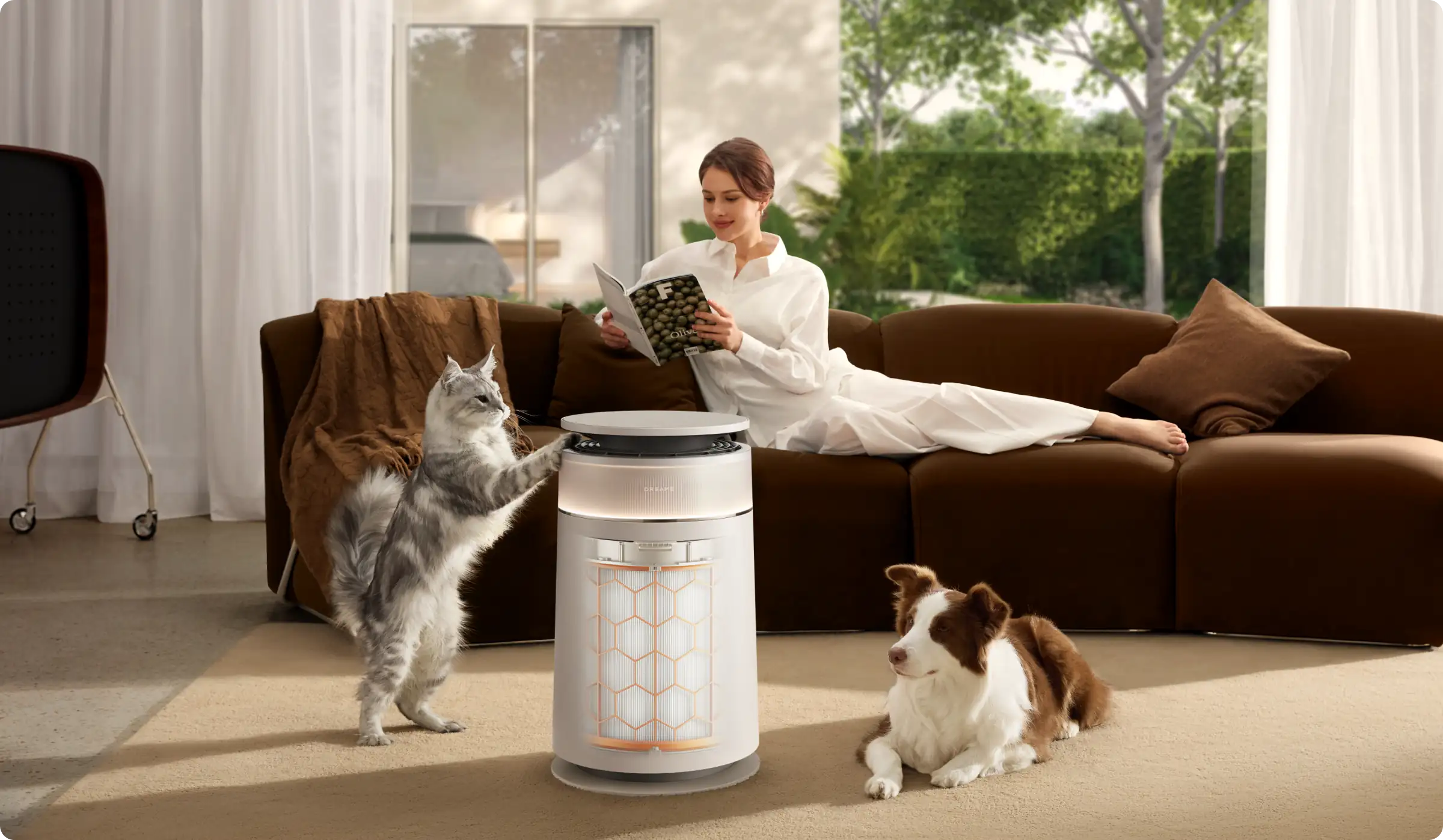 Une femme lit sur un canapé avec un chat et un chien à côté.