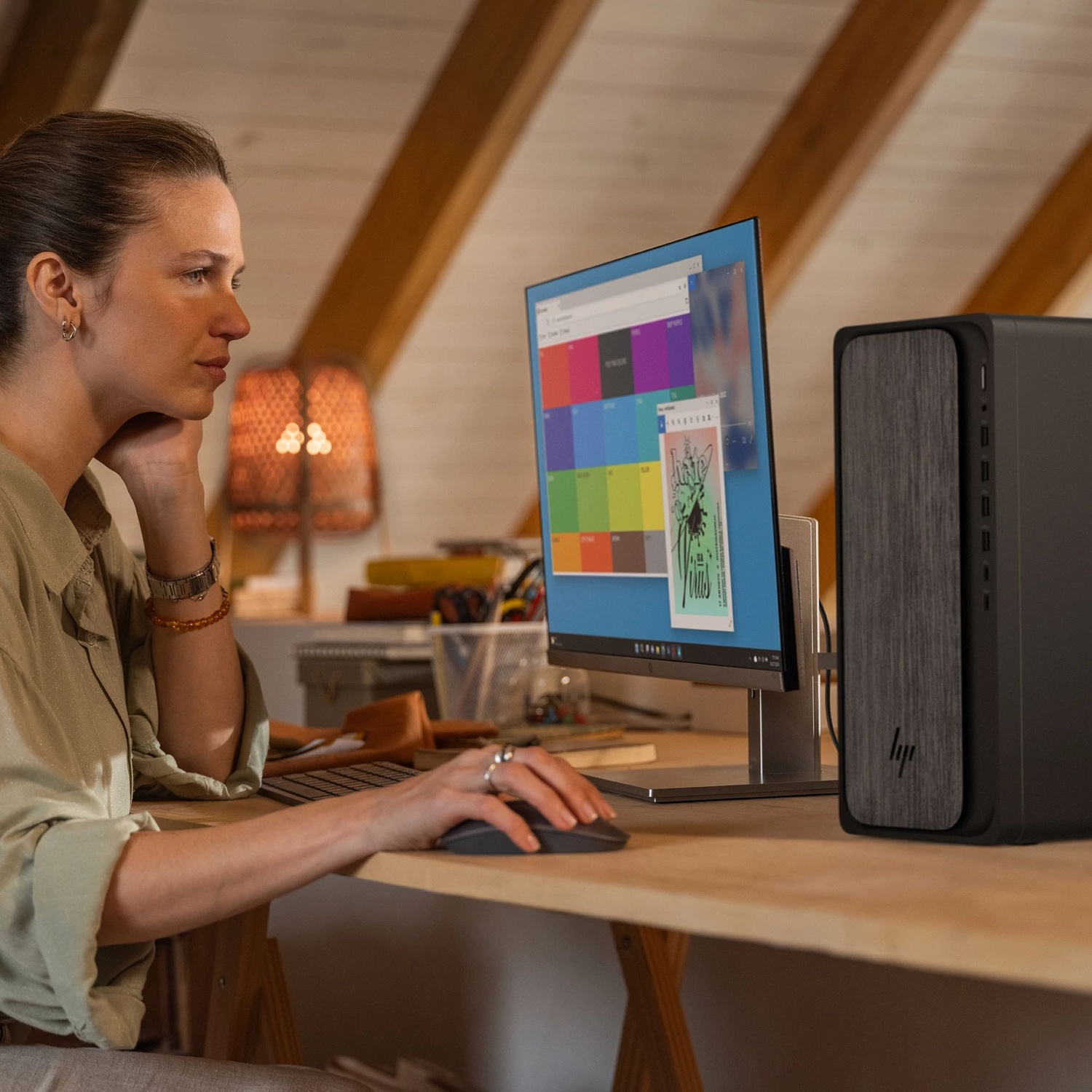Woman working at a computer in an attic office with wood ceilings.