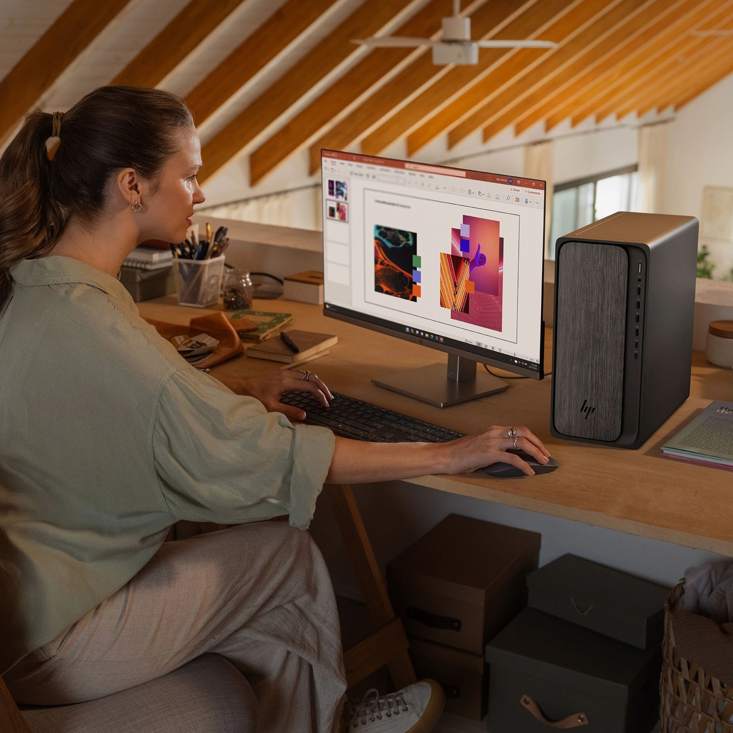 Woman works on computer in attic office with wooden beams.