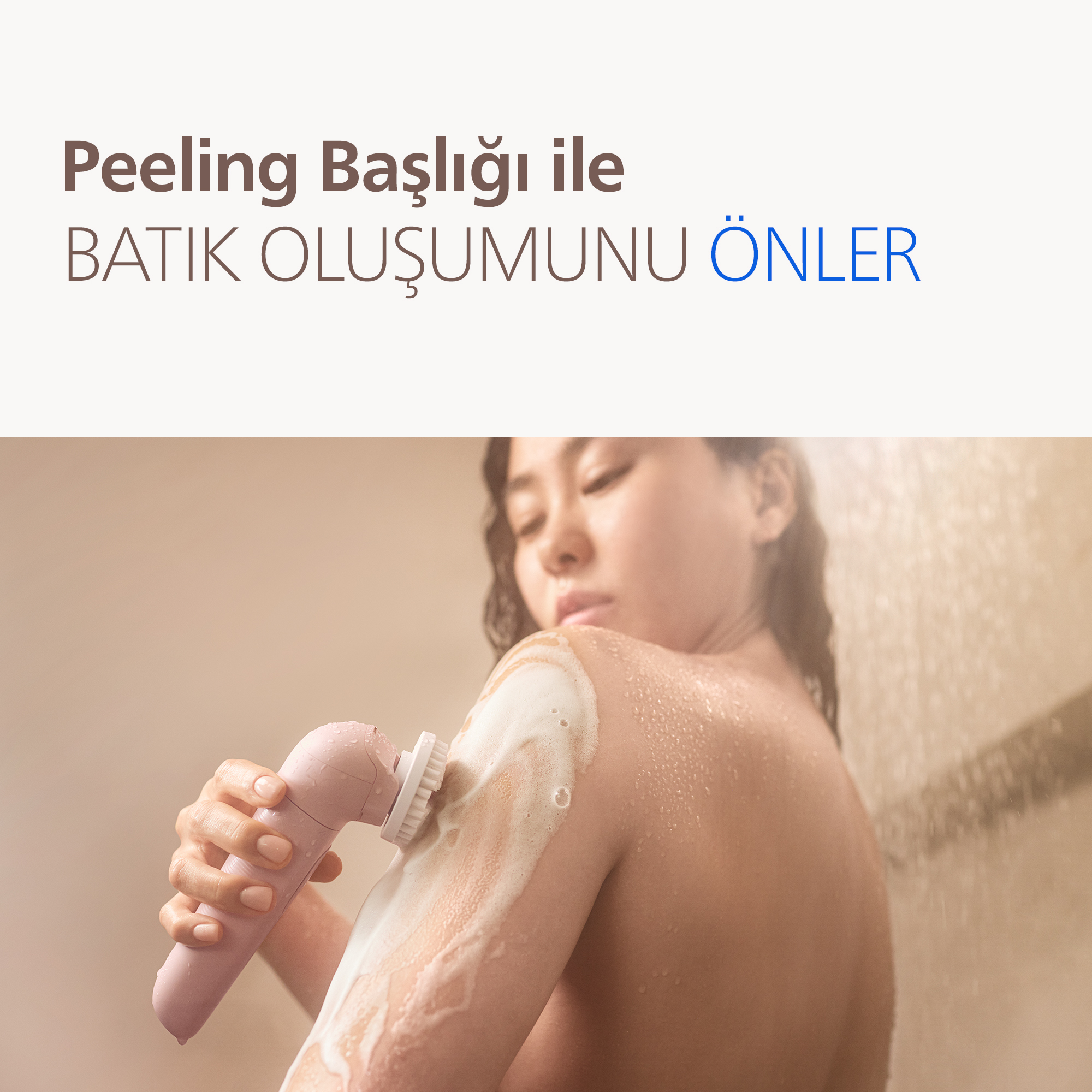 Kadın duşta pembe peeling başlığı kullanıyor.