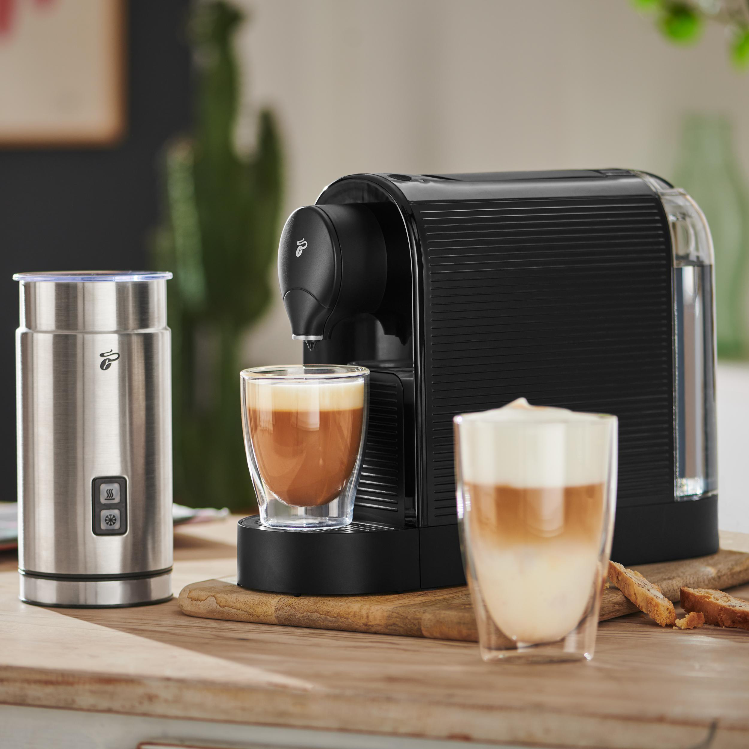 Eine schwarze Kaffeemaschine mit zwei Gläsern Kaffee und einem Milchaufschäumer.