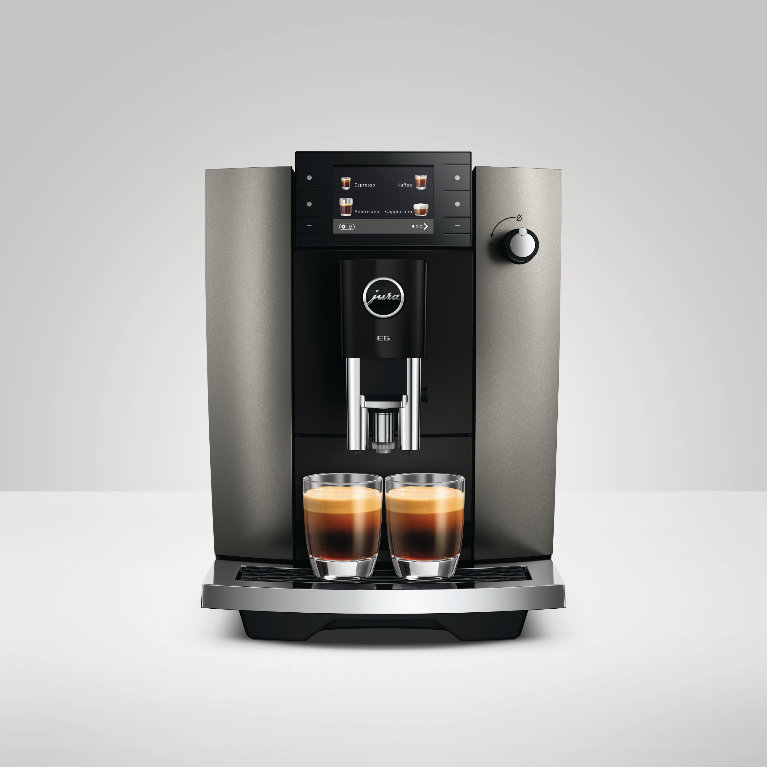 Eine Jura E6 Kaffeemaschine mit zwei Gläsern Espresso auf weißem Hintergrund.