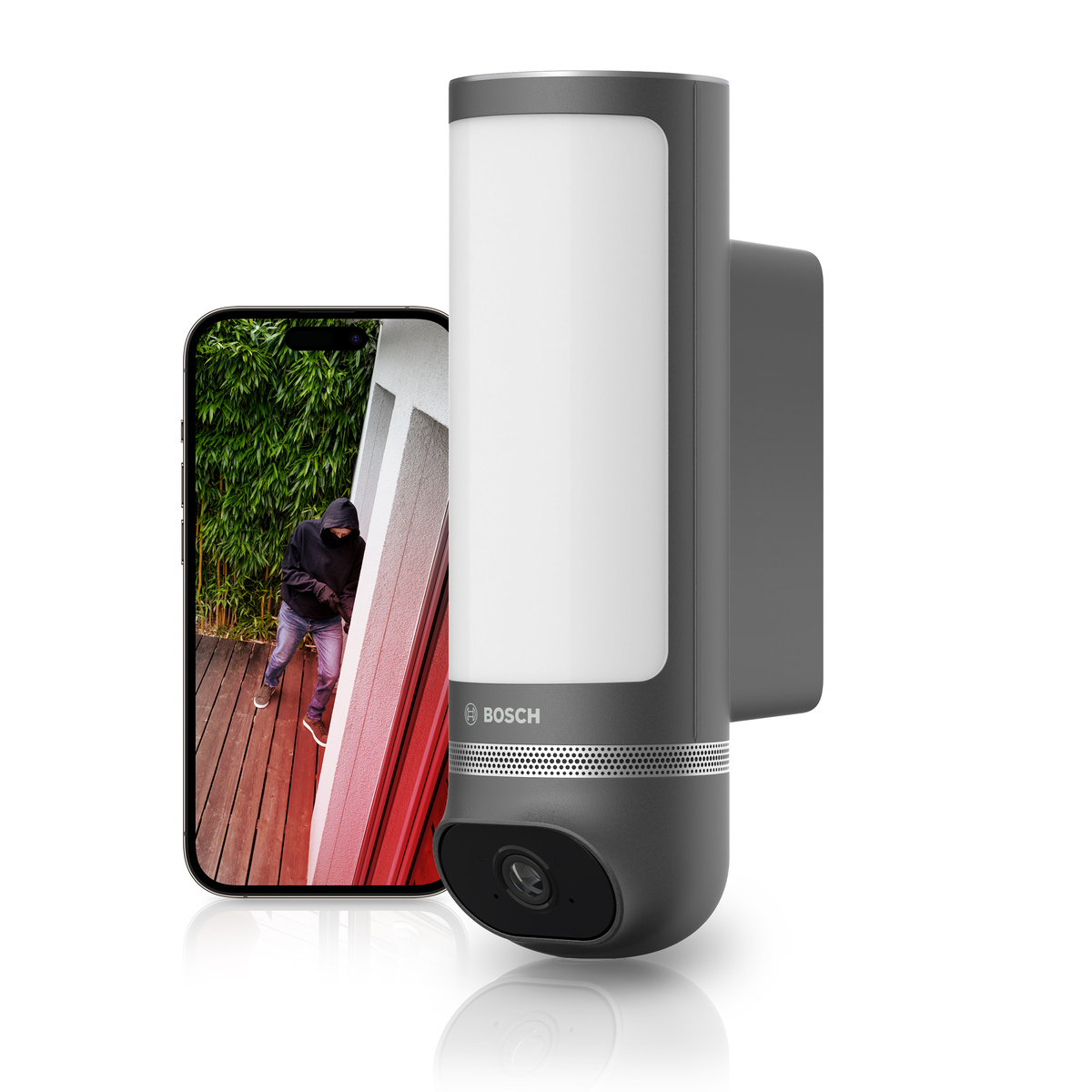 Eine dunkle Sicherheitskamera mit Licht neben einem Handy, das einen Einbrecher zeigt.