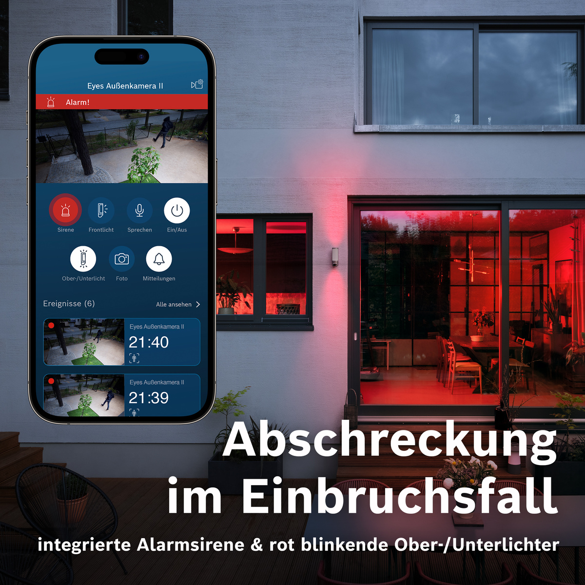 Ein Smartphone zeigt eine Überwachungs-App mit Alarm an. Draußen blinken rote Lichter.