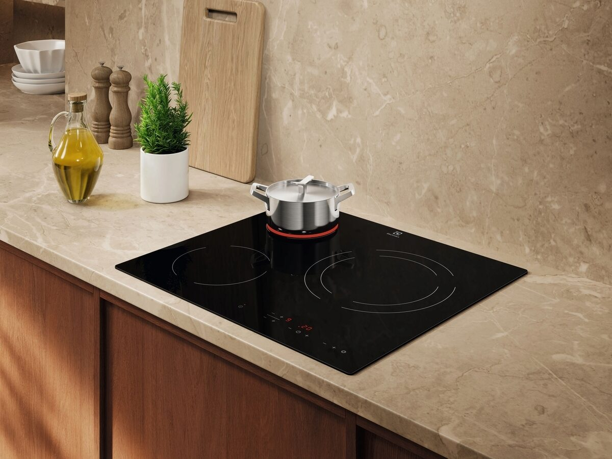 Una cocina moderna con vitrocerámica de inducción negra con una olla.