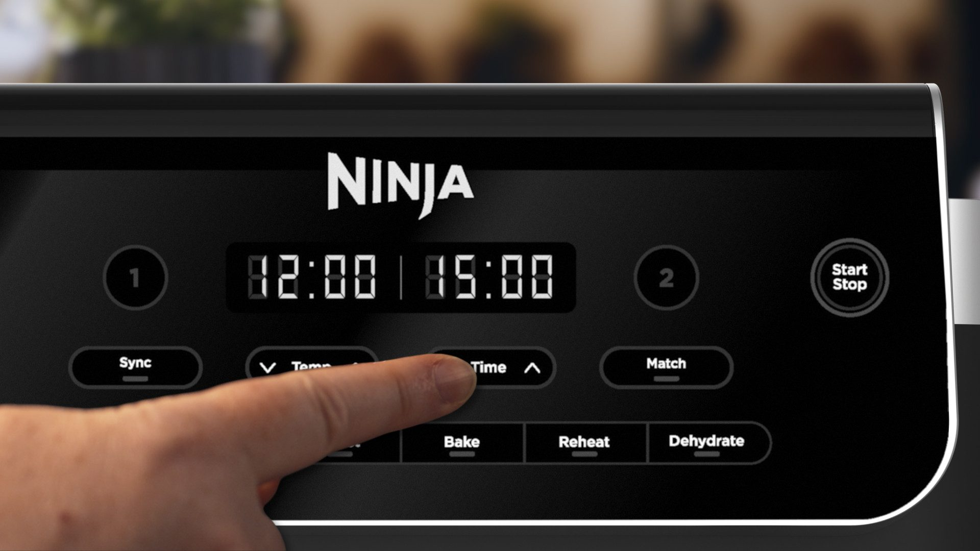 Un dedo presiona el botón 'Hora' en un panel de control negro de horno Ninja con pantallas digitales.