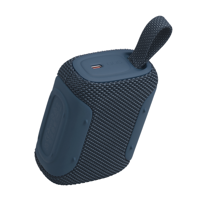 Un altavoz Bluetooth portátil azul con rejilla de tela y asa.