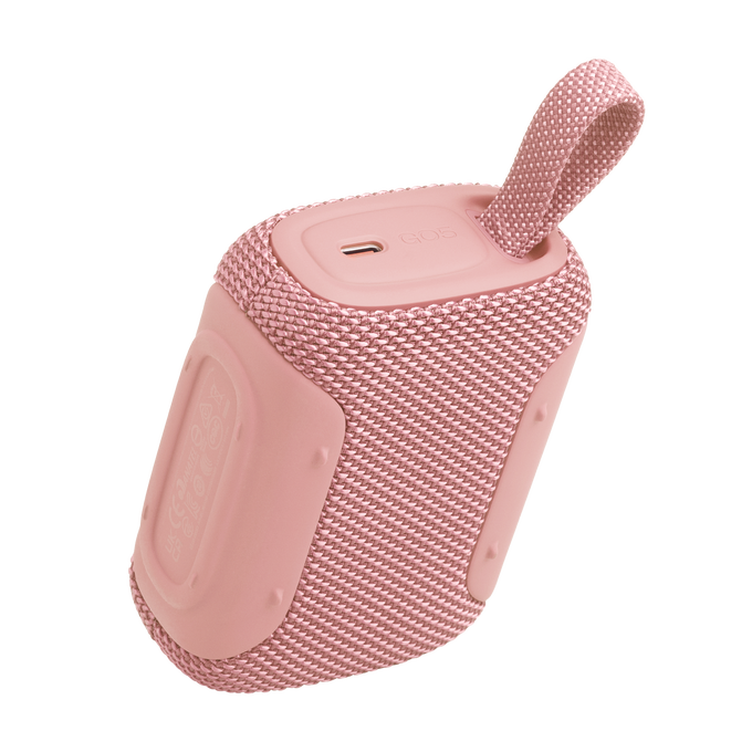 Un altavoz Bluetooth rosa con acabado de tela y asa.
