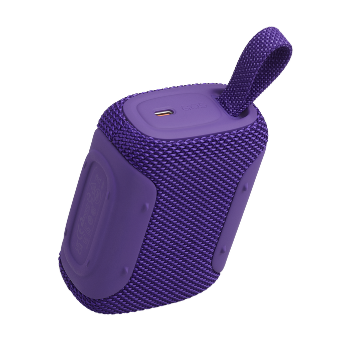 Altavoz Bluetooth morado con asa y puerto USB-C, sobre fondo negro.