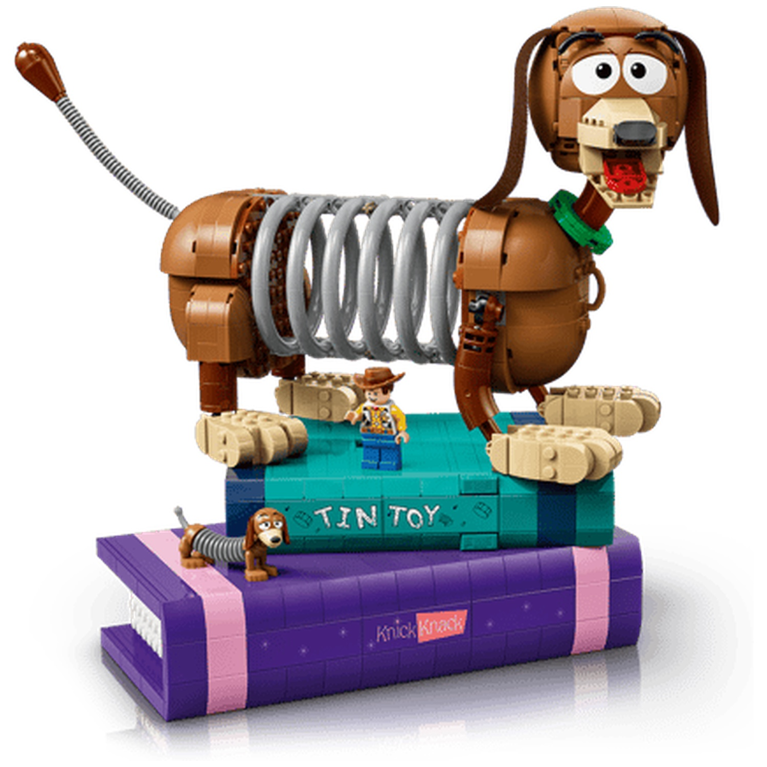 Een Lego Slinky hond staat op boeken naast een kleine Lego-figuur en een kleinere hond.