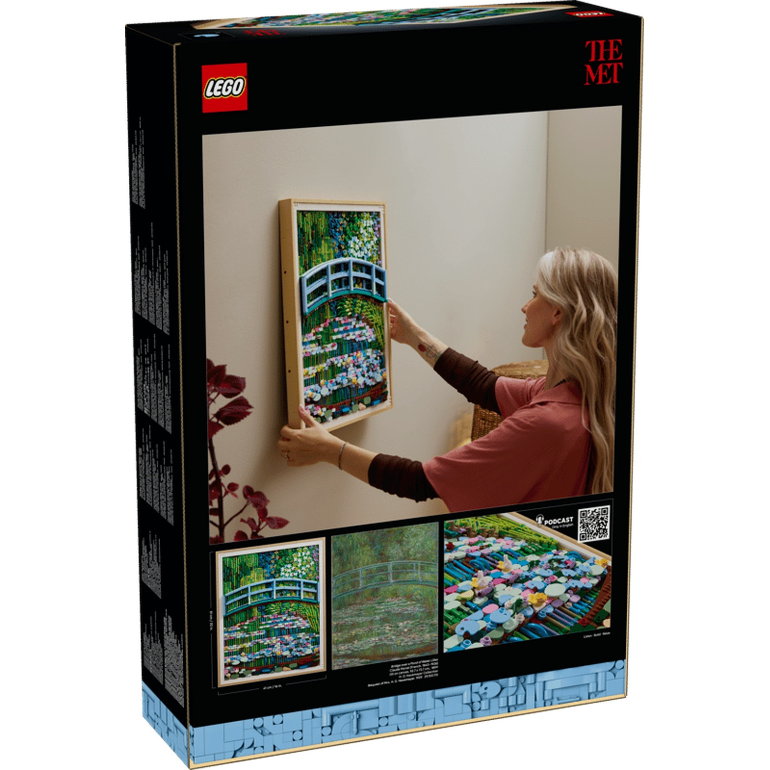 A woman hangs a LEGO picture of Monet's Japanese bridge.