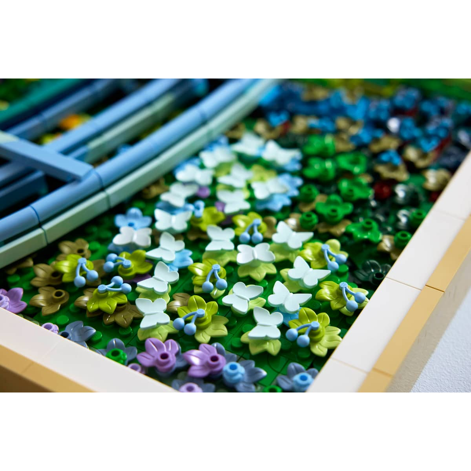 Colorful Lego flowers and butterflies in a frame with blue lattice elements.