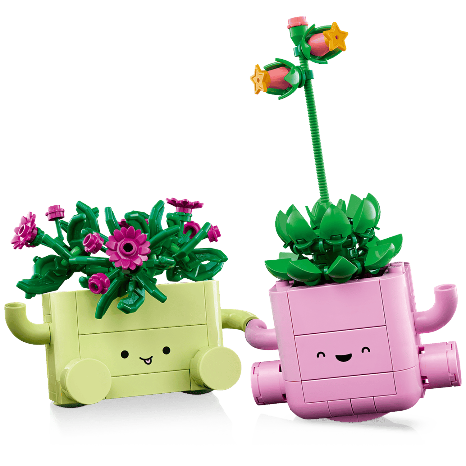 Twee Lego plantenbakken met gezichten, één lichtgroen met roze bloemen, één roze met sterbloemen.