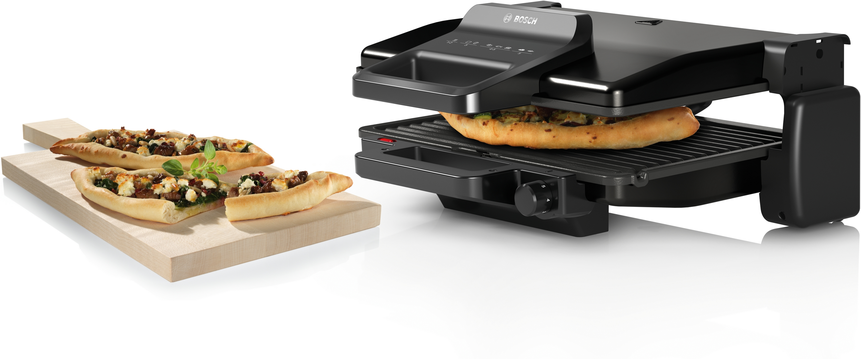 Ein schwarzer Bosch Kontaktgrill mit einem halben Pizzabrot und einem halben Sandwich.