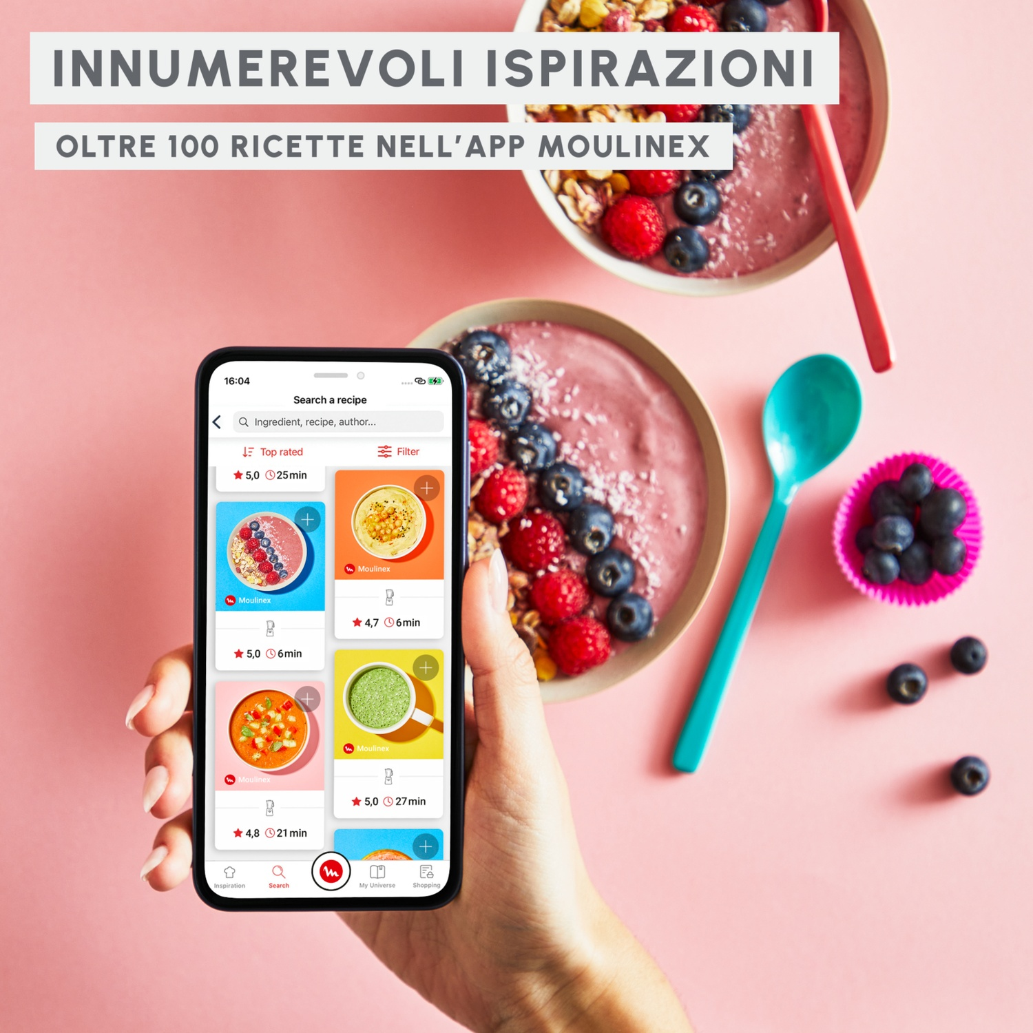 Una mano tiene uno smartphone con ricette. Due ciotole di frutta e yogurt sono vicine.