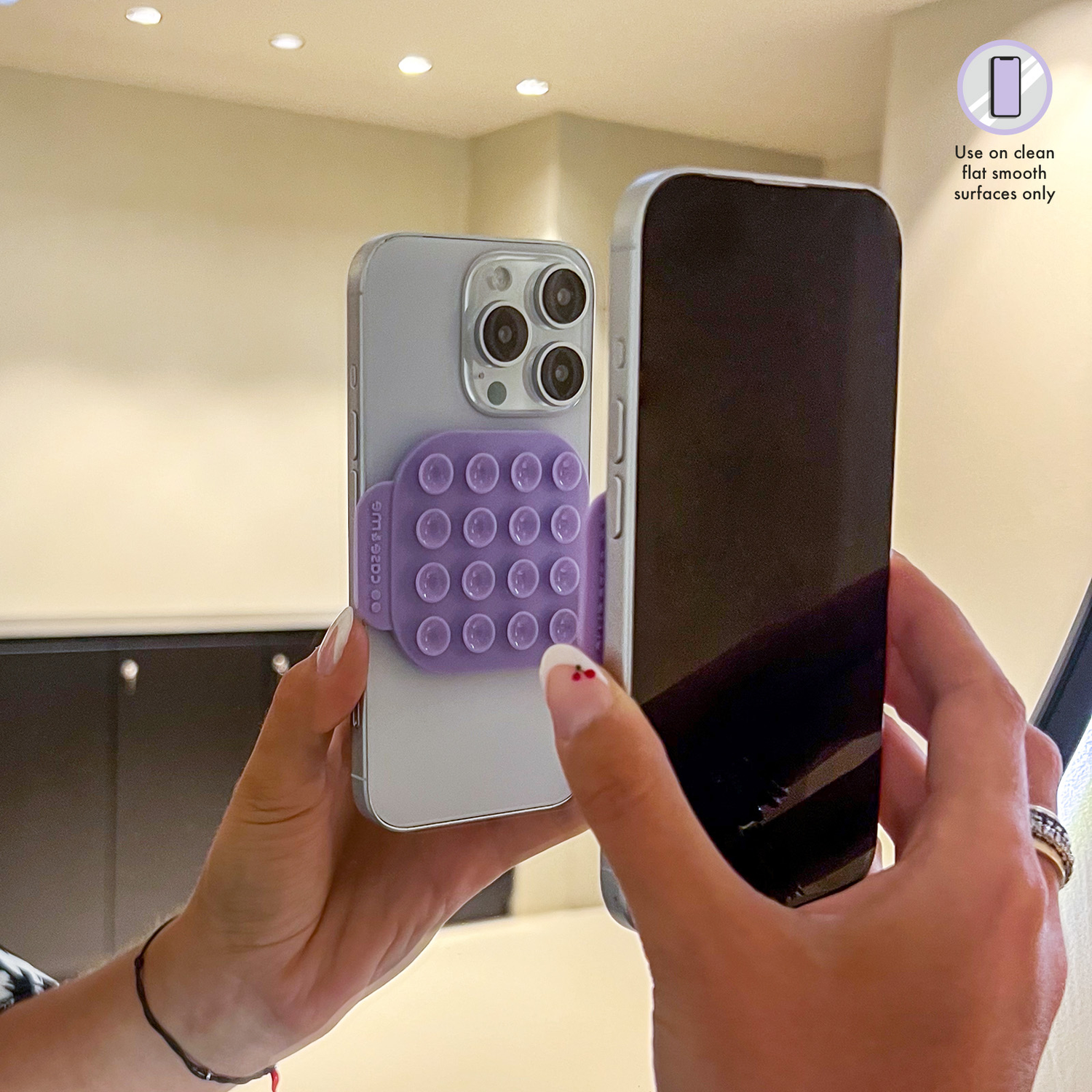 Een hand houdt een paars telefoonaccessoire met zuignappen vast.