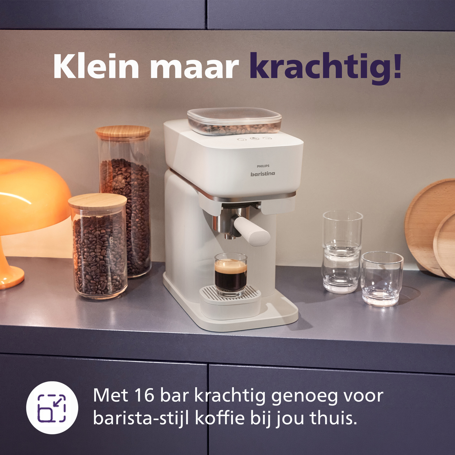 A white coffee machine brews an espresso into a glass. Bean jars are next to it.