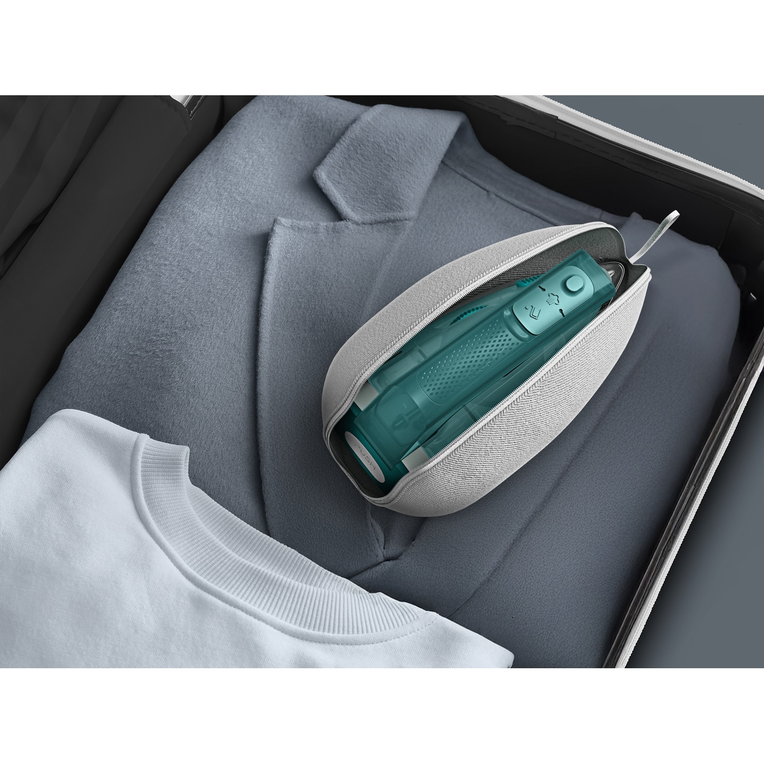 Une brosse à dents électrique turquoise dans une pochette grise repose sur des vêtements dans une valise ouverte.