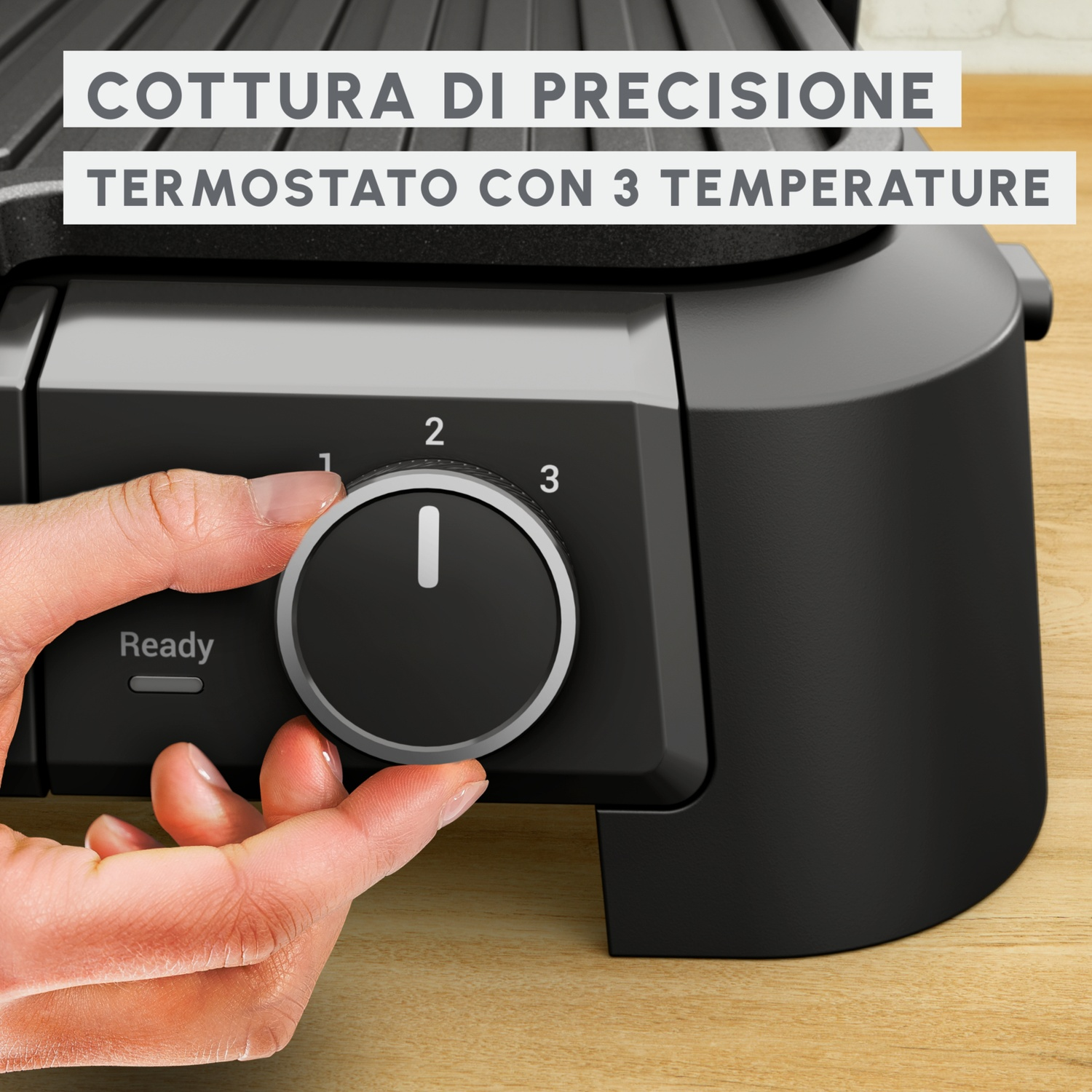 Una mano gira una manopola su un apparecchio nero con 3 impostazioni di temperatura.