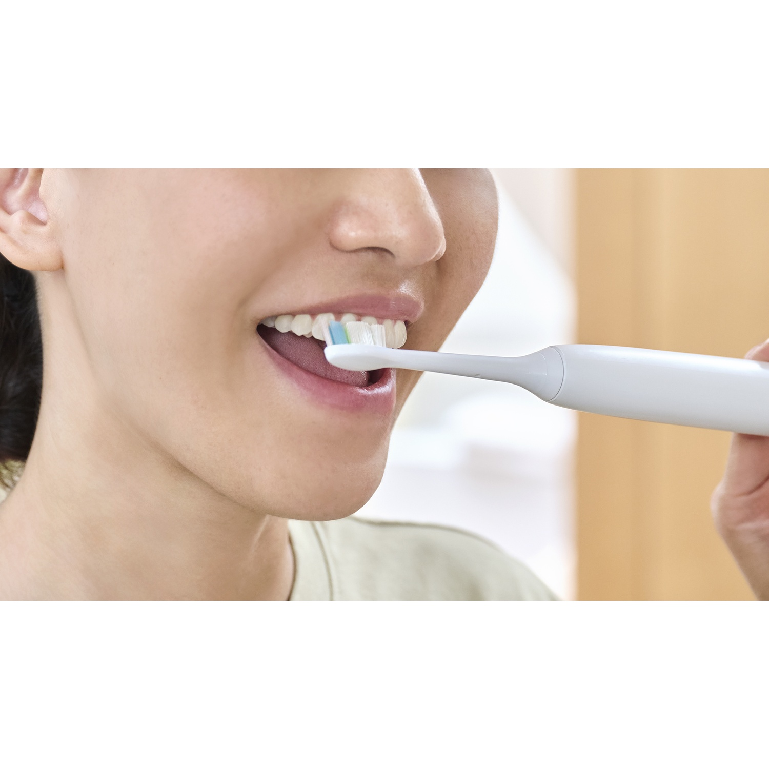 Primo piano di una persona che si lava i denti con uno spazzolino elettrico.