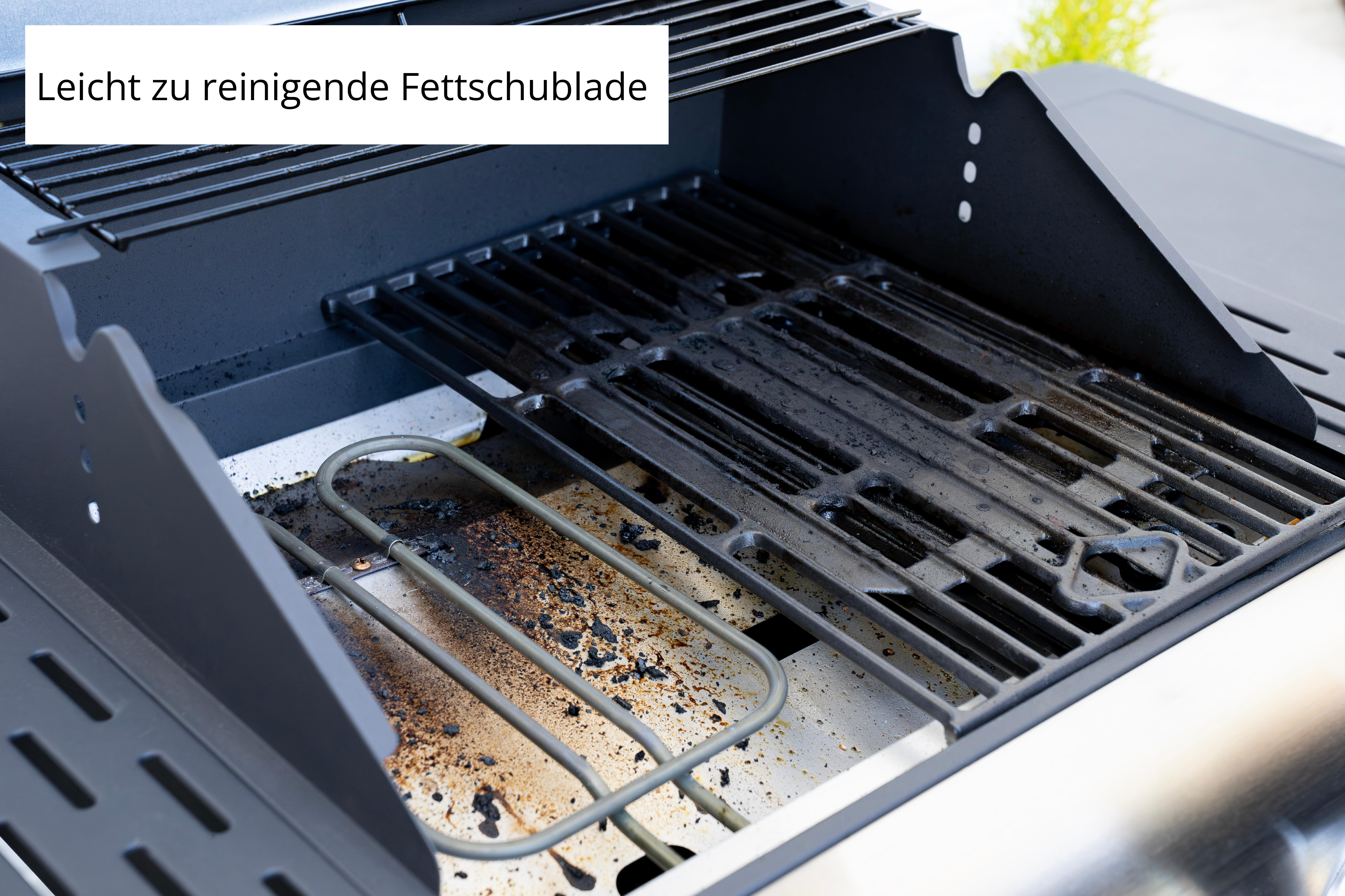 Ein schmutziger Grillrost mit darunterliegendem Heizelement und Fettauffangschale.