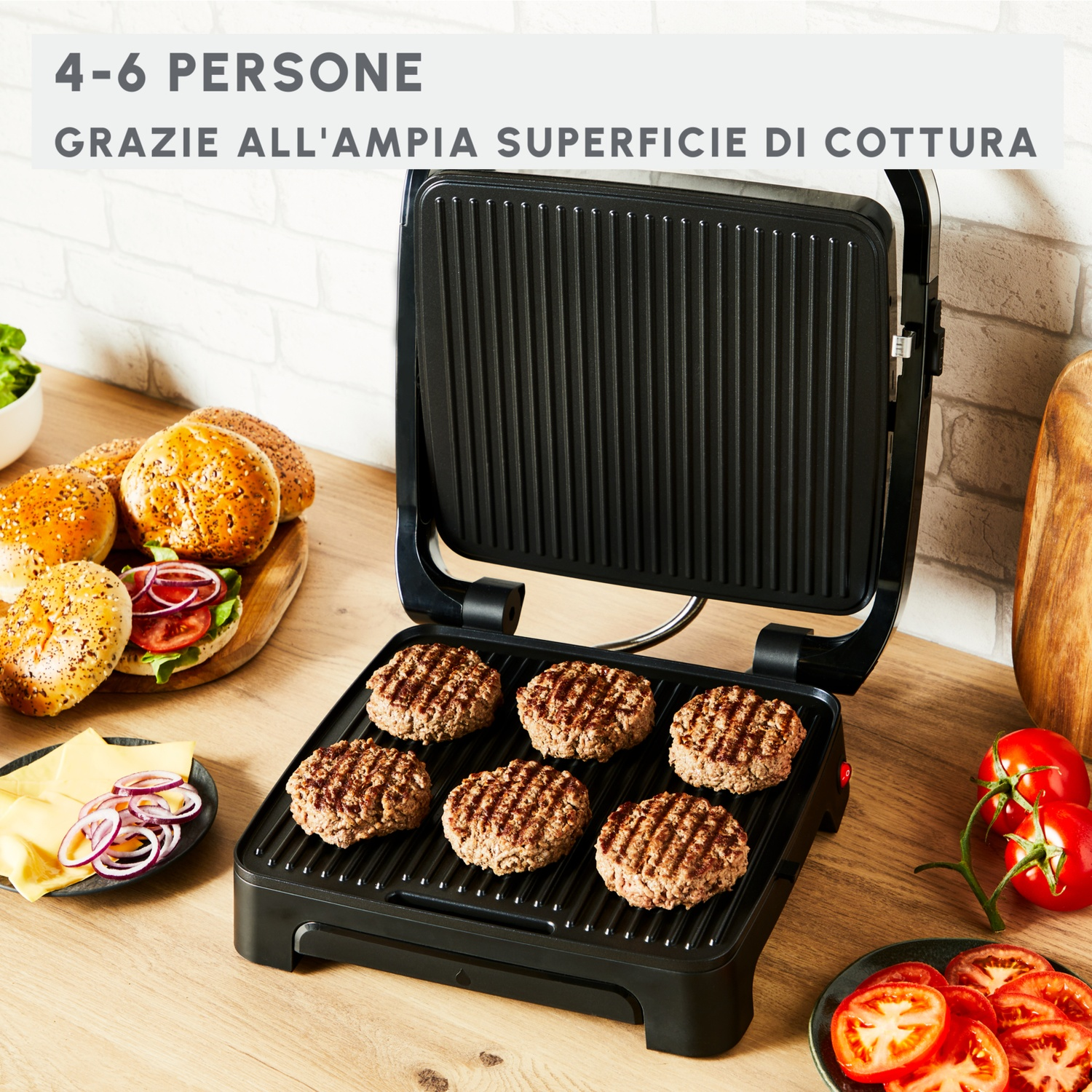 Un grill a contatto con sei patty, panini, formaggio, cipolle e pomodori.